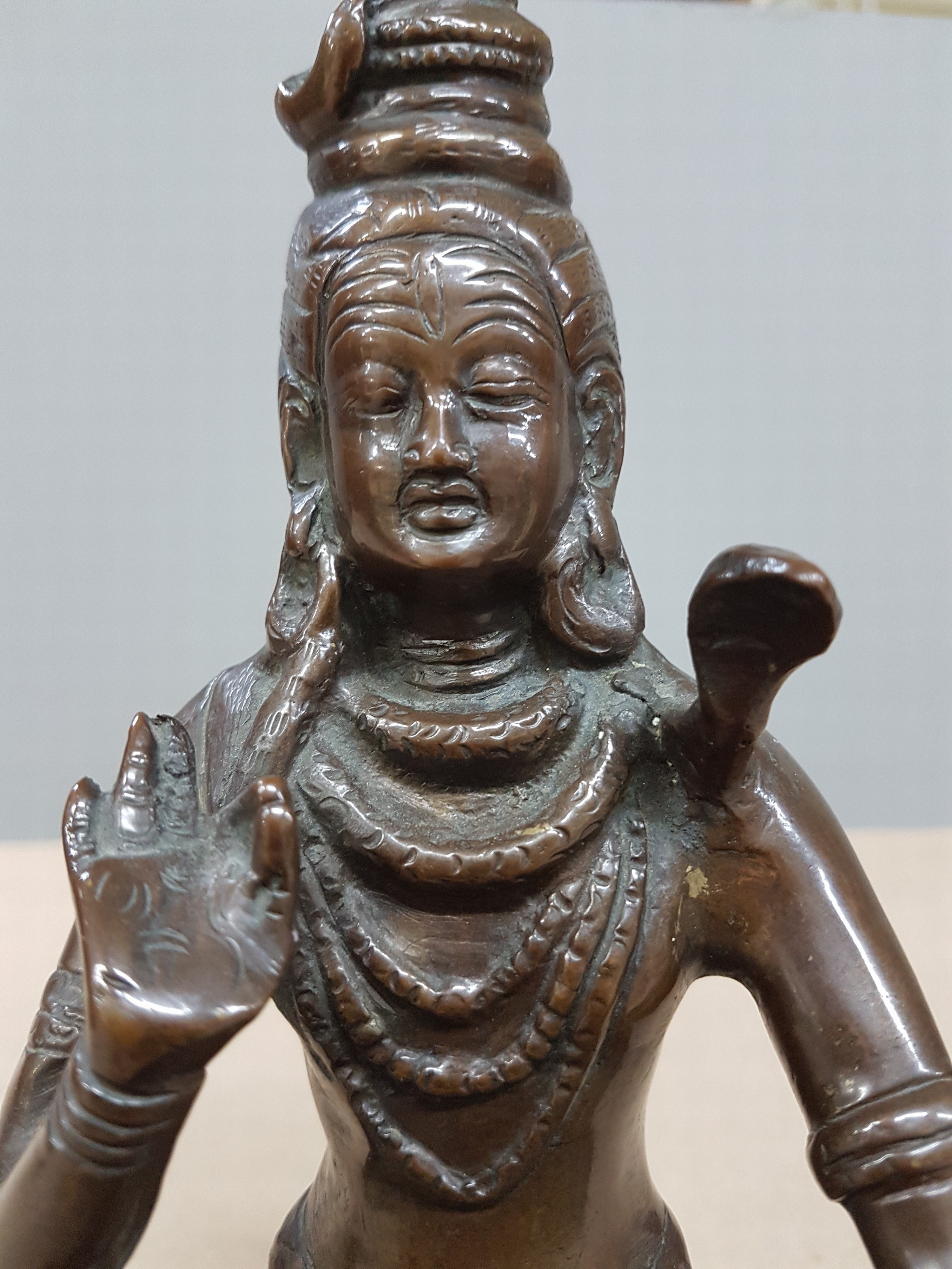 Detail e: Bronzefigur/Shiva, Indien, wohl 19. Jh., patiniert, mit Schlange um den Hals, auf einem Löwenfell sitzend, H. ca. 21 cm