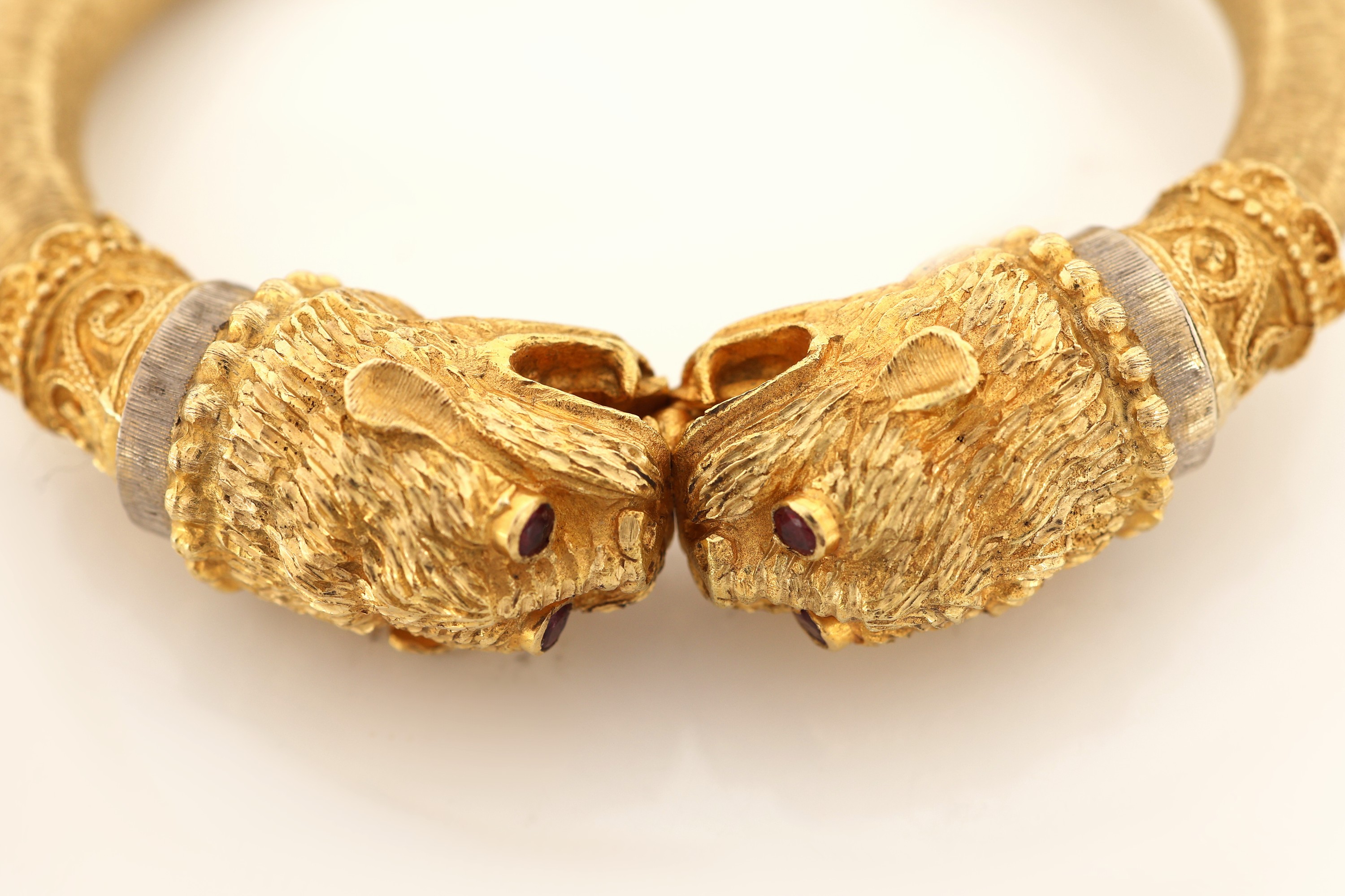 Detail b: 18 kt Gold Rubin-Armreif, GG 750/000, stilisierte Fabelwesenköpfe, Augen rundfacett.Rubine, offen gearbeitet, Klappscharnier, wohlhohl, ca. 46 g