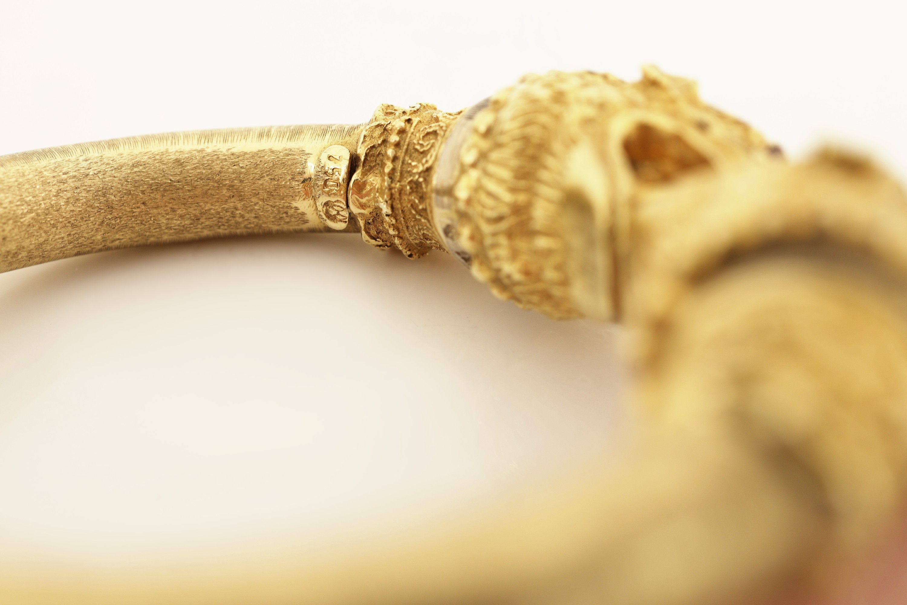 Detail c: 18 kt Gold Rubin-Armreif, GG 750/000, stilisierte Fabelwesenköpfe, Augen rundfacett.Rubine, offen gearbeitet, Klappscharnier, wohlhohl, ca. 46 g