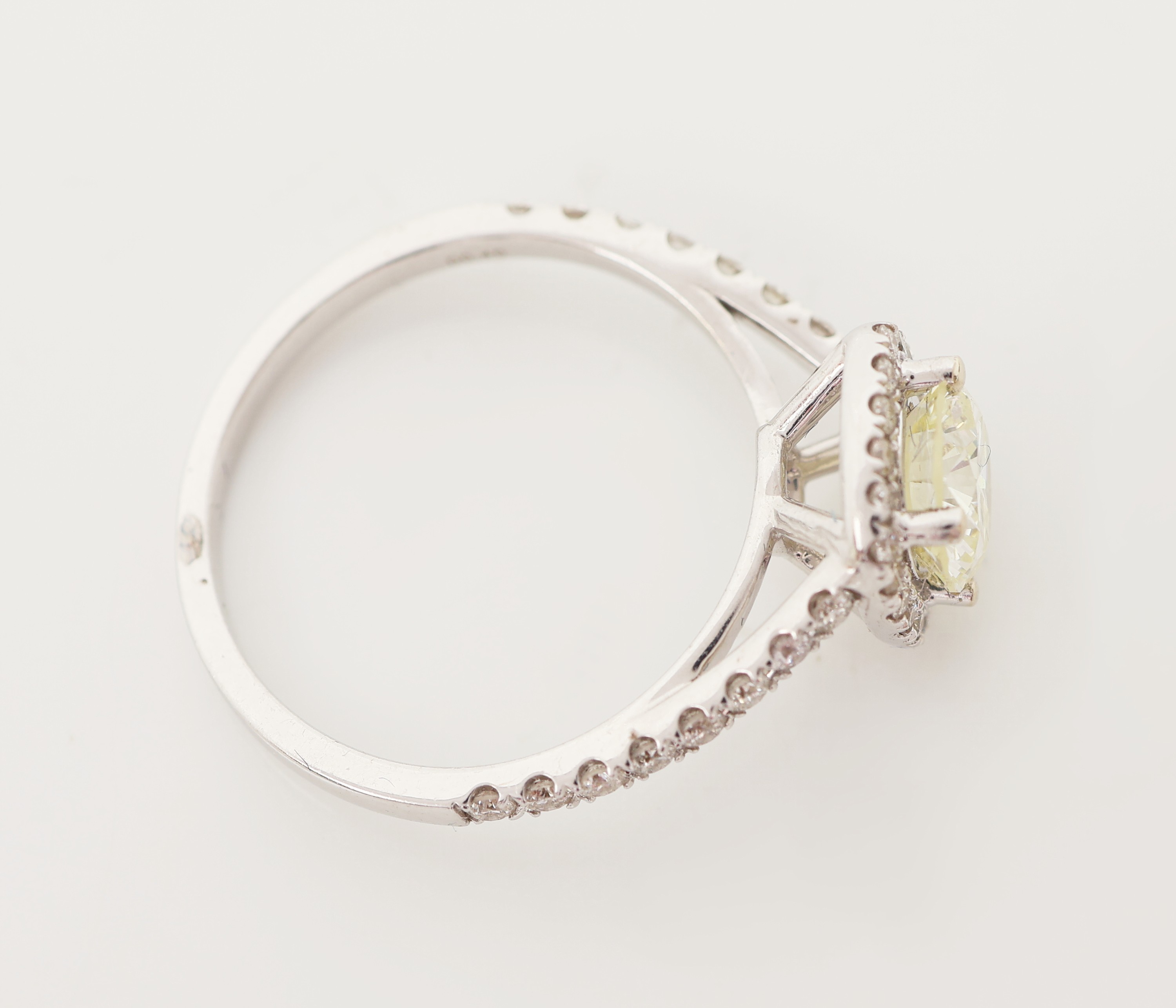 Detail c: 18 kt Gold Brillant-Ring, WG 750/000, mittig Brillant ca. 1.05 ct light Yellow/vs, weitere Brillanten zus. ca. 0.40 ct (grav.) ...