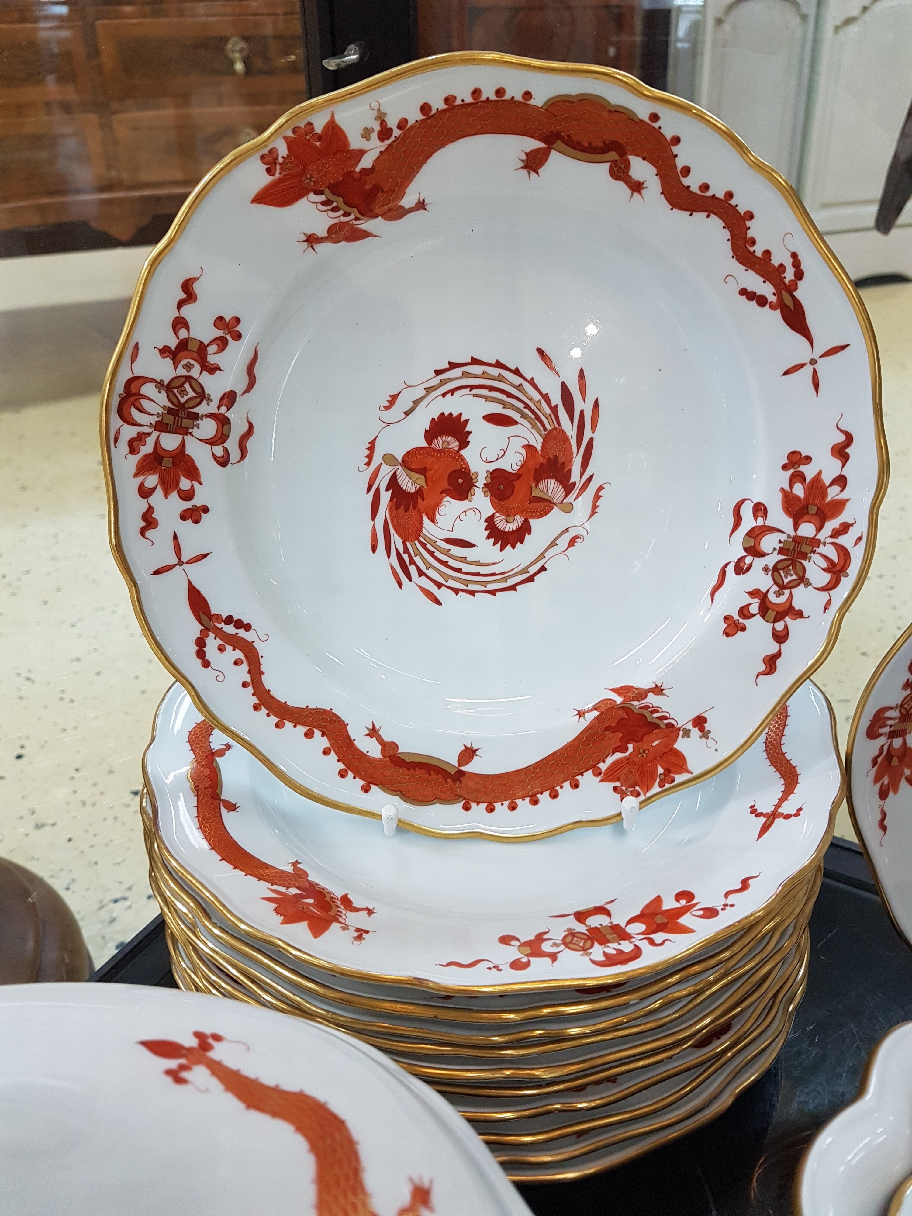 Detail b: Umfangreiches Tafelservice, Meissen, 20. Jh., roter Hofdrache, golden gehöht, 11 Menueteller, 8 Teller D. 20 cm, 6 Suppentassen mit Untertassen, 2 ...
