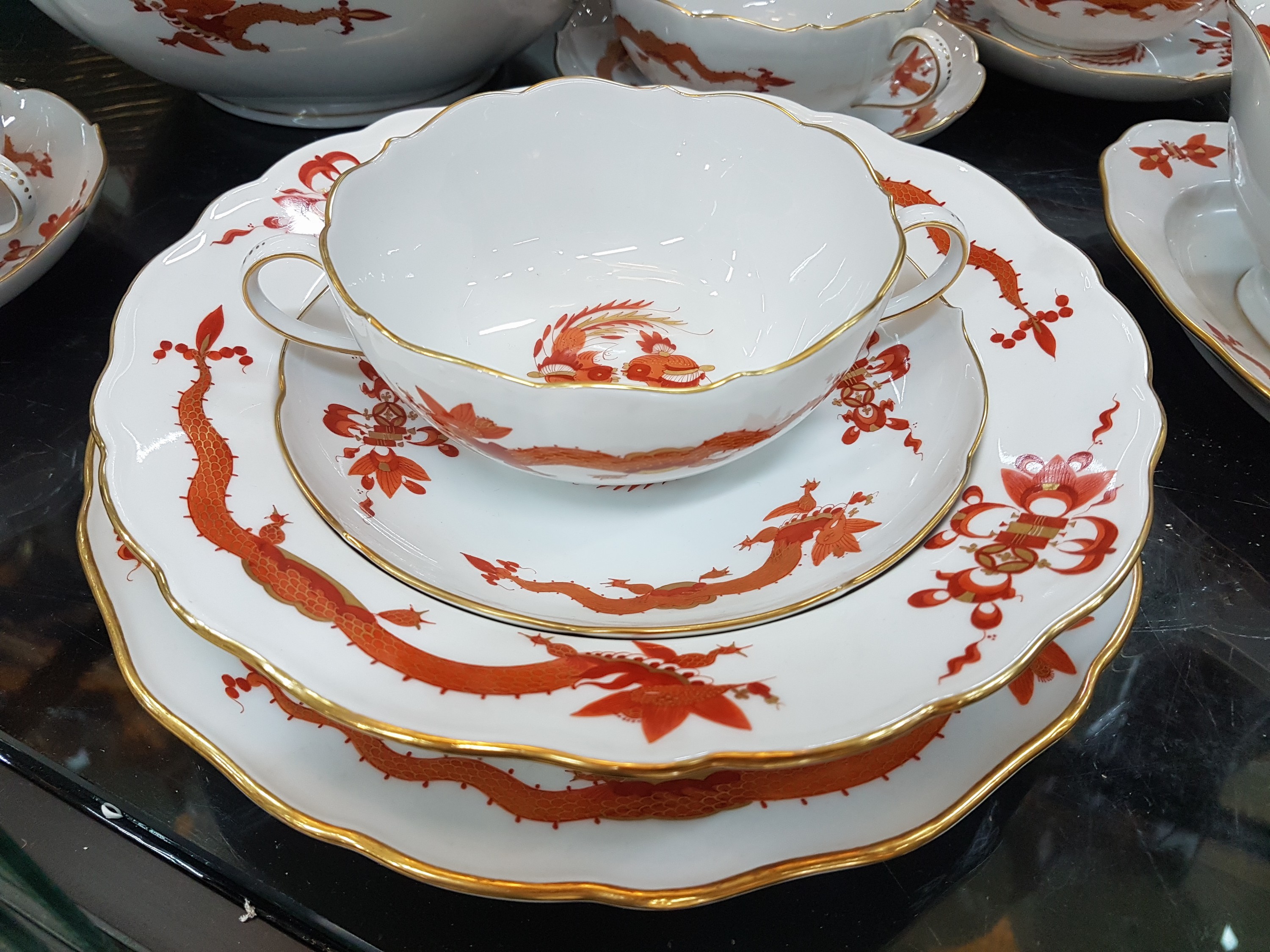 Detail j: Umfangreiches Tafelservice, Meissen, 20. Jh., roter Hofdrache, golden gehöht, 11 Menueteller, 8 Teller D. 20 cm, 6 Suppentassen mit Untertassen, 2 ...