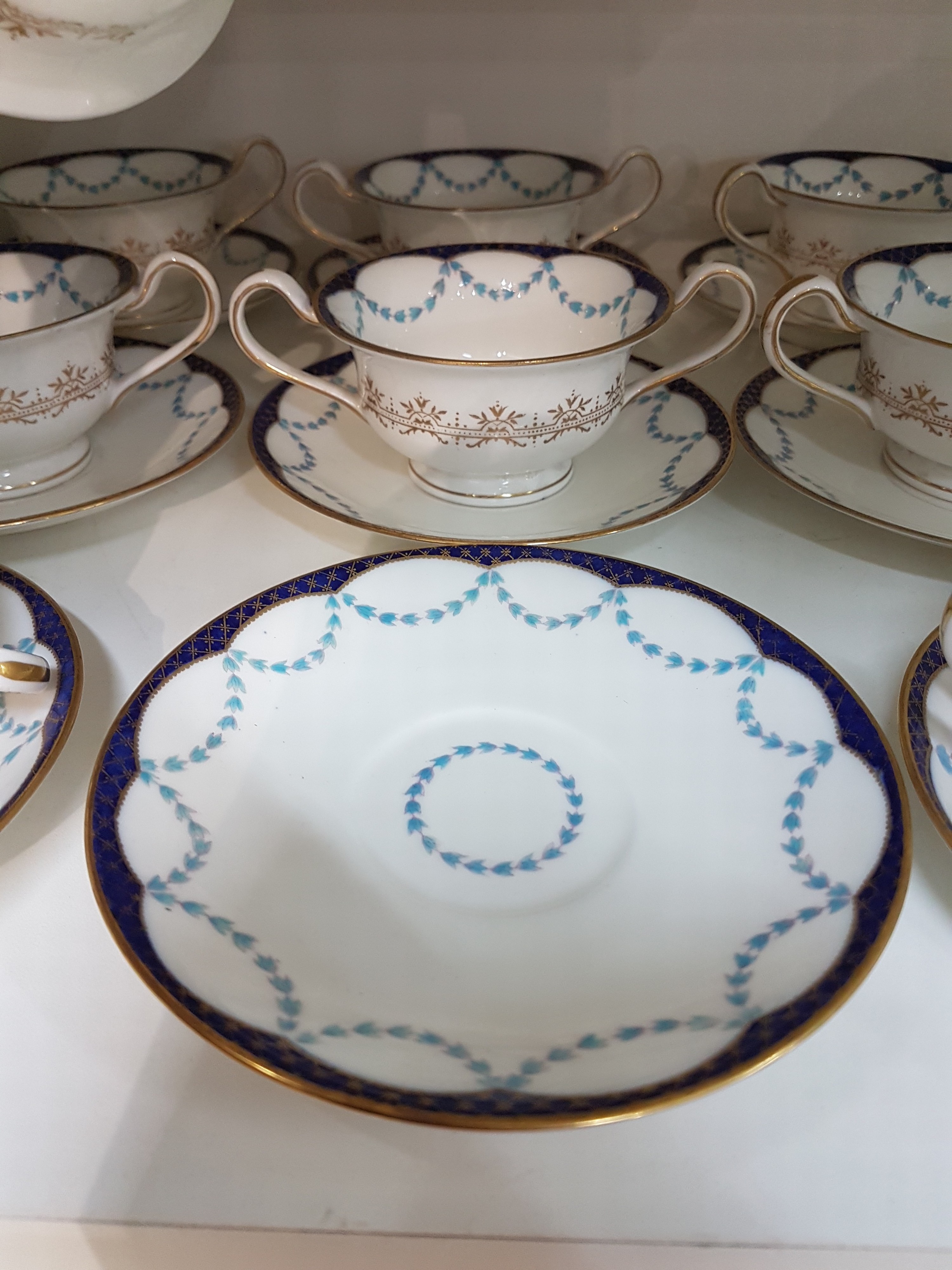 Detail d: 12 Gedecke Ribbon and Roses, Wedgwood, London, um 1900, Porzellan, farbiger Dekor mit Goldstaffage, 12 Doppelhenkeltassen mit UT, Alterssp.