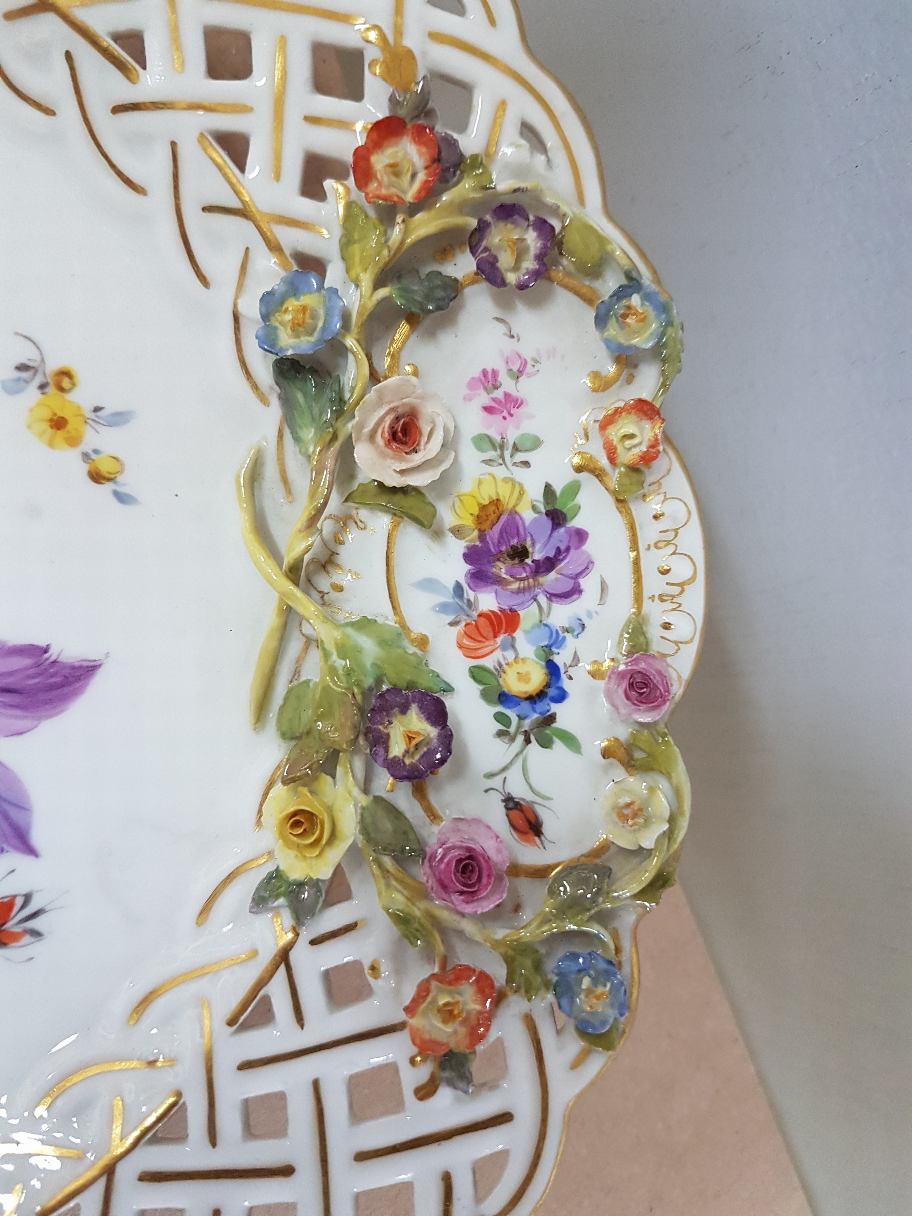 Detail d: Dessertteller, Meissen, um 1900, Knaufschwerter Porzellan, Wandung mit Durchbrucharbeit, aufgelegte Blütenapplikationen, Fahne mit Durchbrucharbeit, ...