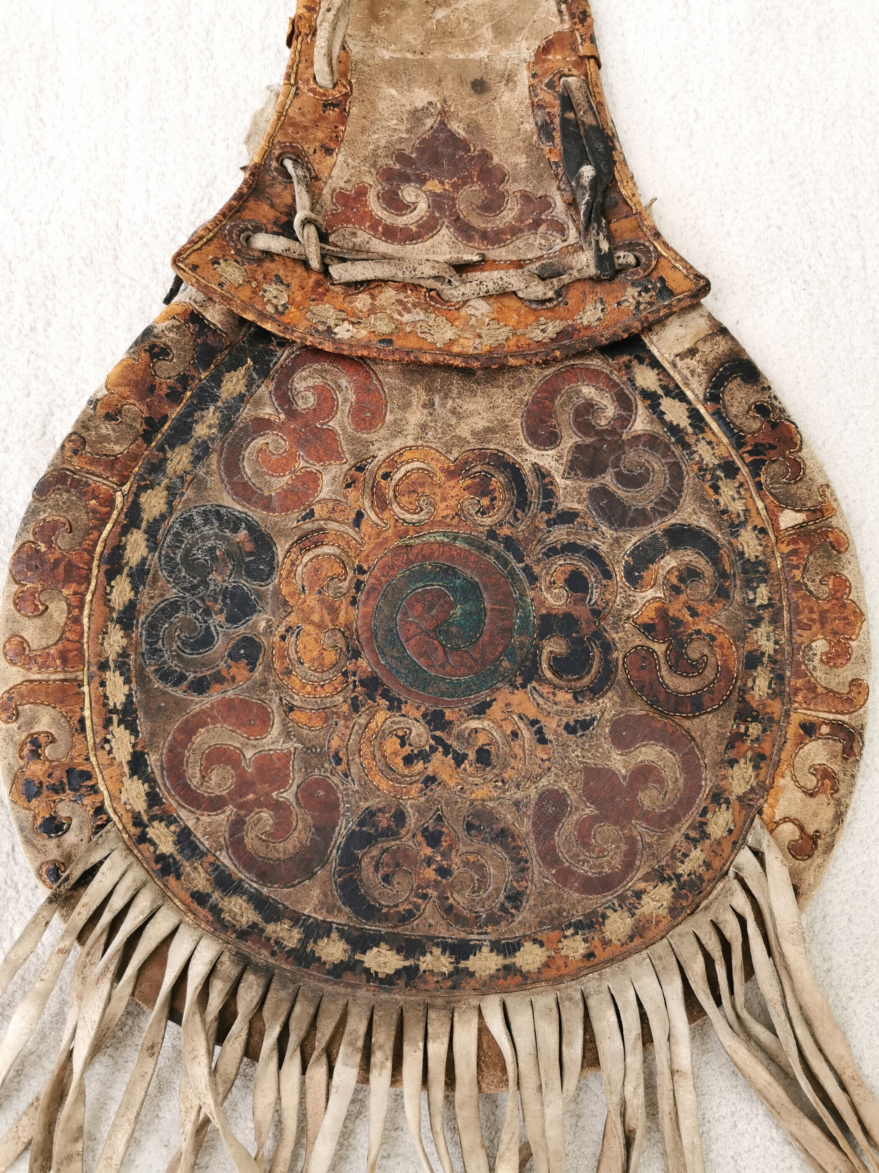 Detail b: Satteltasche aus Leder, Tibet/Mongolei, 18./19.Jh., Leder, belegt mit farbig gebeiztem Leder in floralem Muster, Fransenbehang, Eisenringe, deutliche ...