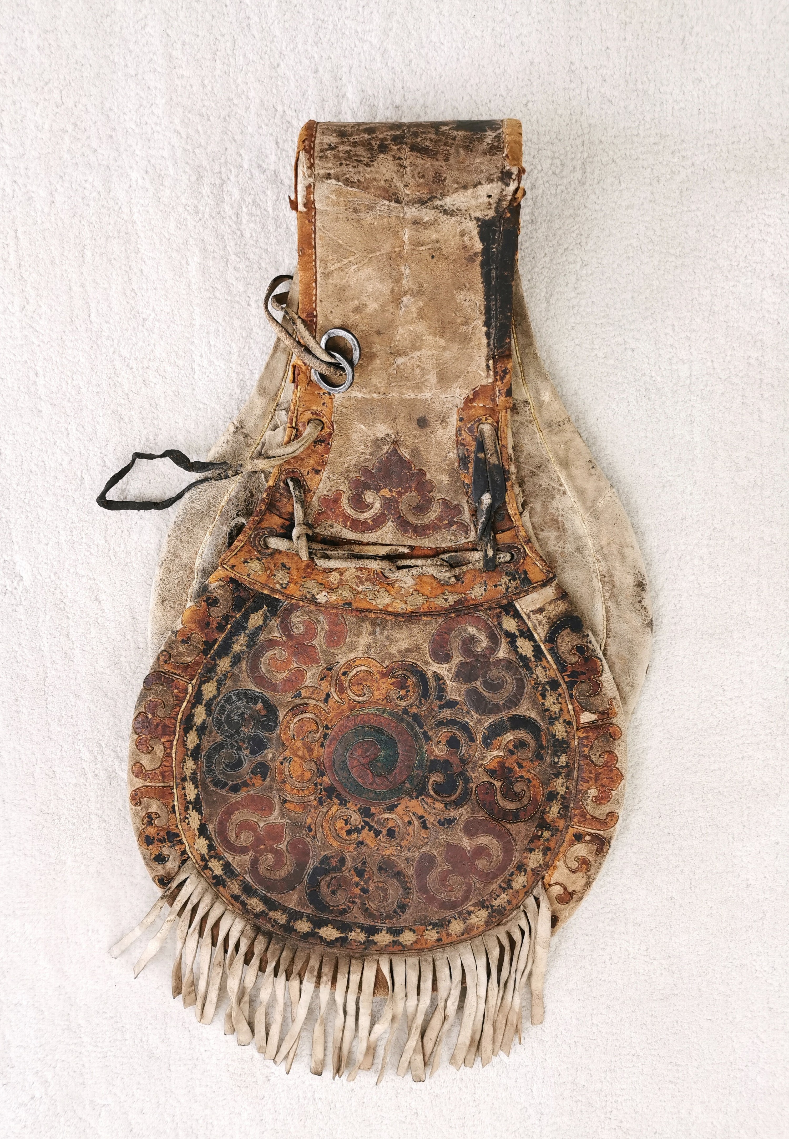 Detail e: Satteltasche aus Leder, Tibet/Mongolei, 18./19.Jh., Leder, belegt mit farbig gebeiztem Leder in floralem Muster, Fransenbehang, Eisenringe, deutliche ...