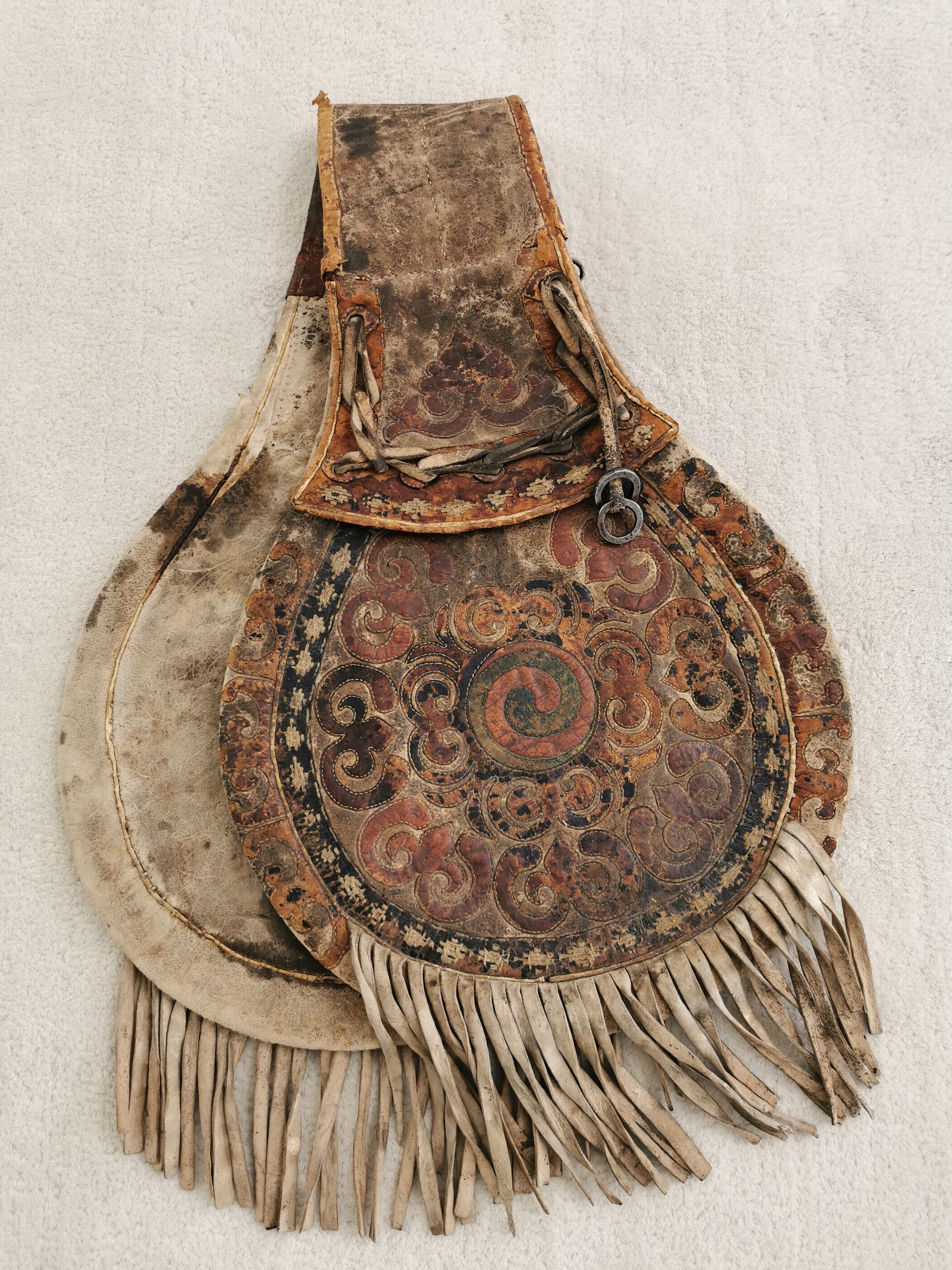 Detail f: Satteltasche aus Leder, Tibet/Mongolei, 18./19.Jh., Leder, belegt mit farbig gebeiztem Leder in floralem Muster, Fransenbehang, Eisenringe, deutliche ...