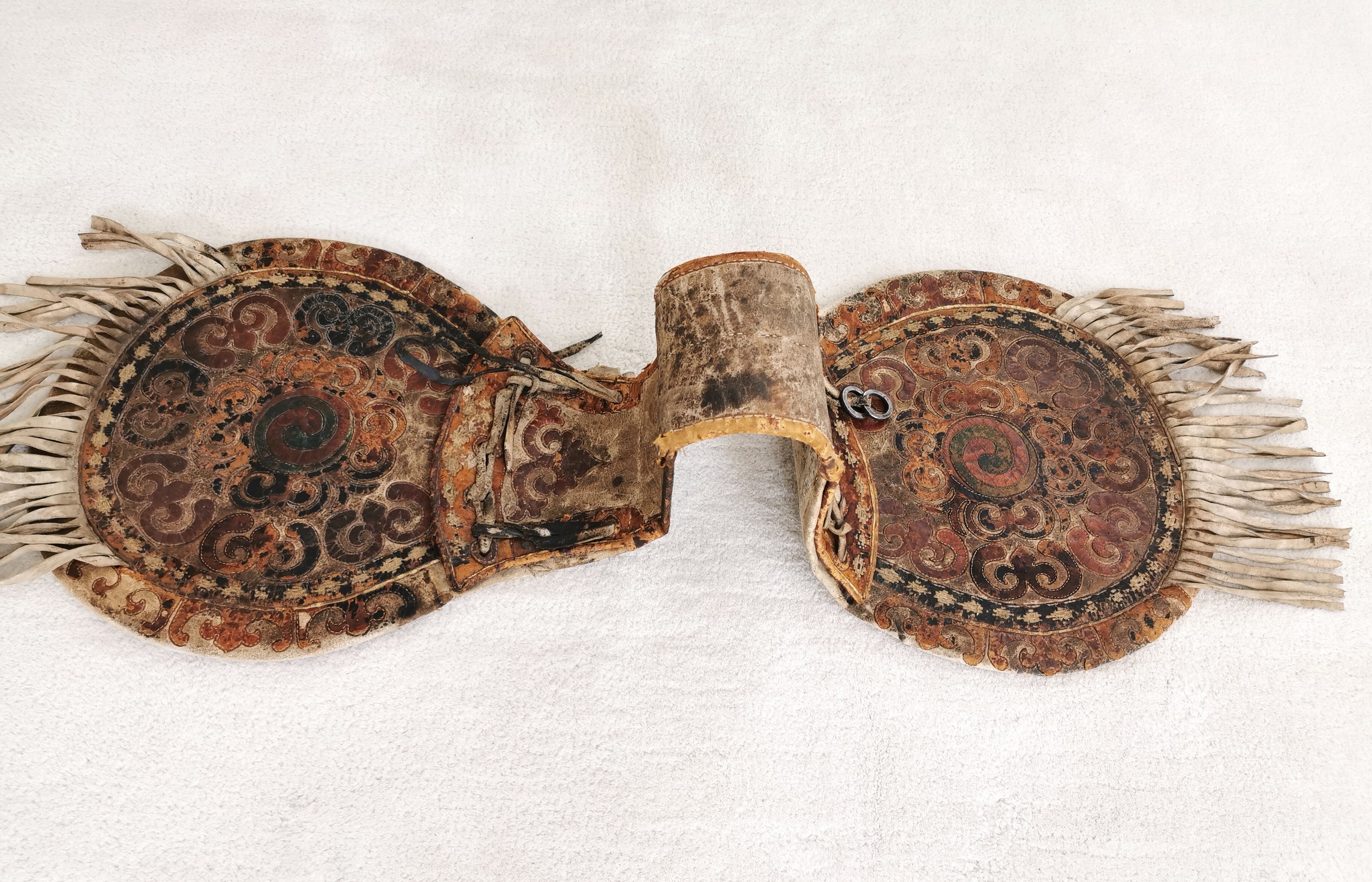 Detail i: Satteltasche aus Leder, Tibet/Mongolei, 18./19.Jh., Leder, belegt mit farbig gebeiztem Leder in floralem Muster, Fransenbehang, Eisenringe, deutliche ...