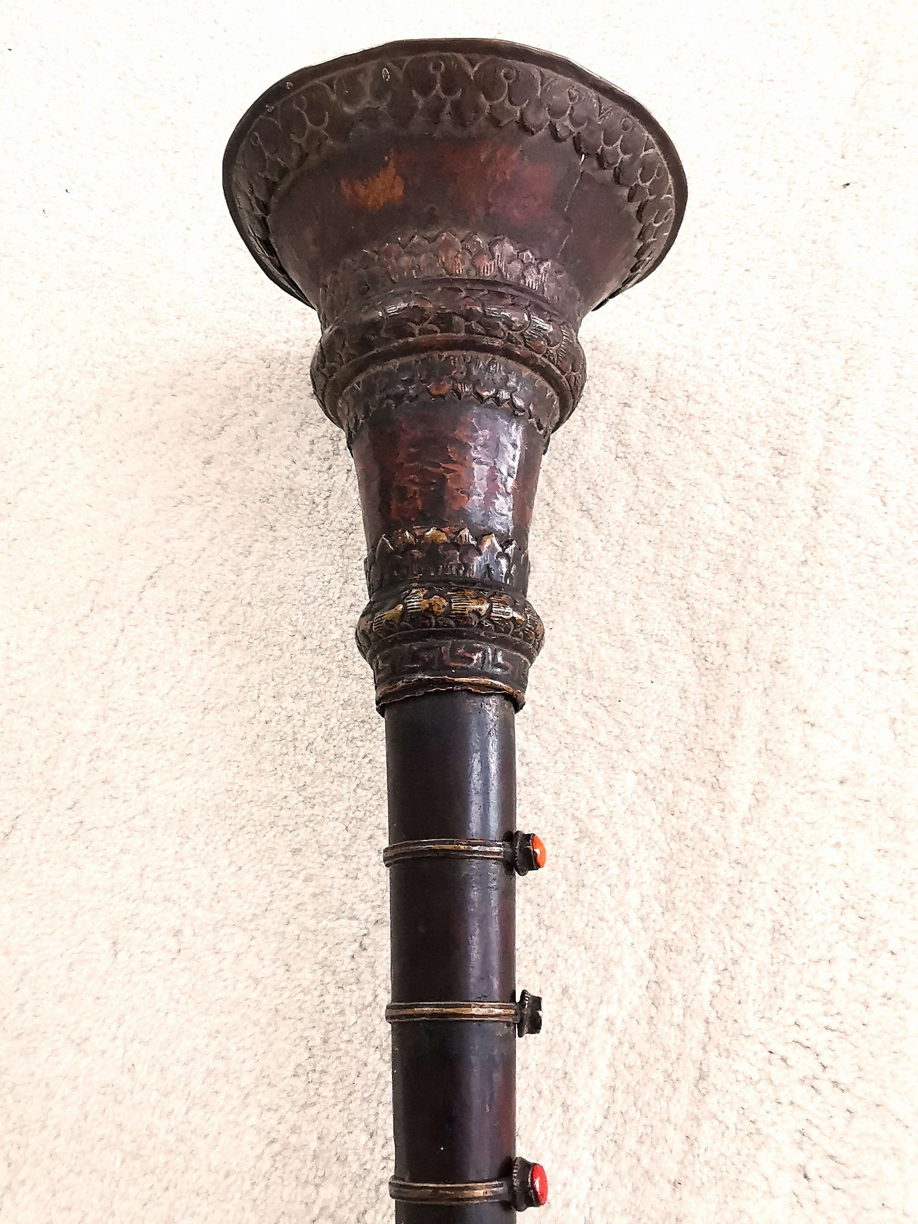 Detail d: Schalmei, Tibet, 19.Jh., Holzkorpus, Beschlag aus Bronze und Messing, gefasste Glassteine, angehängtes Mundstück, L. 54 cm; Provenienz: ...