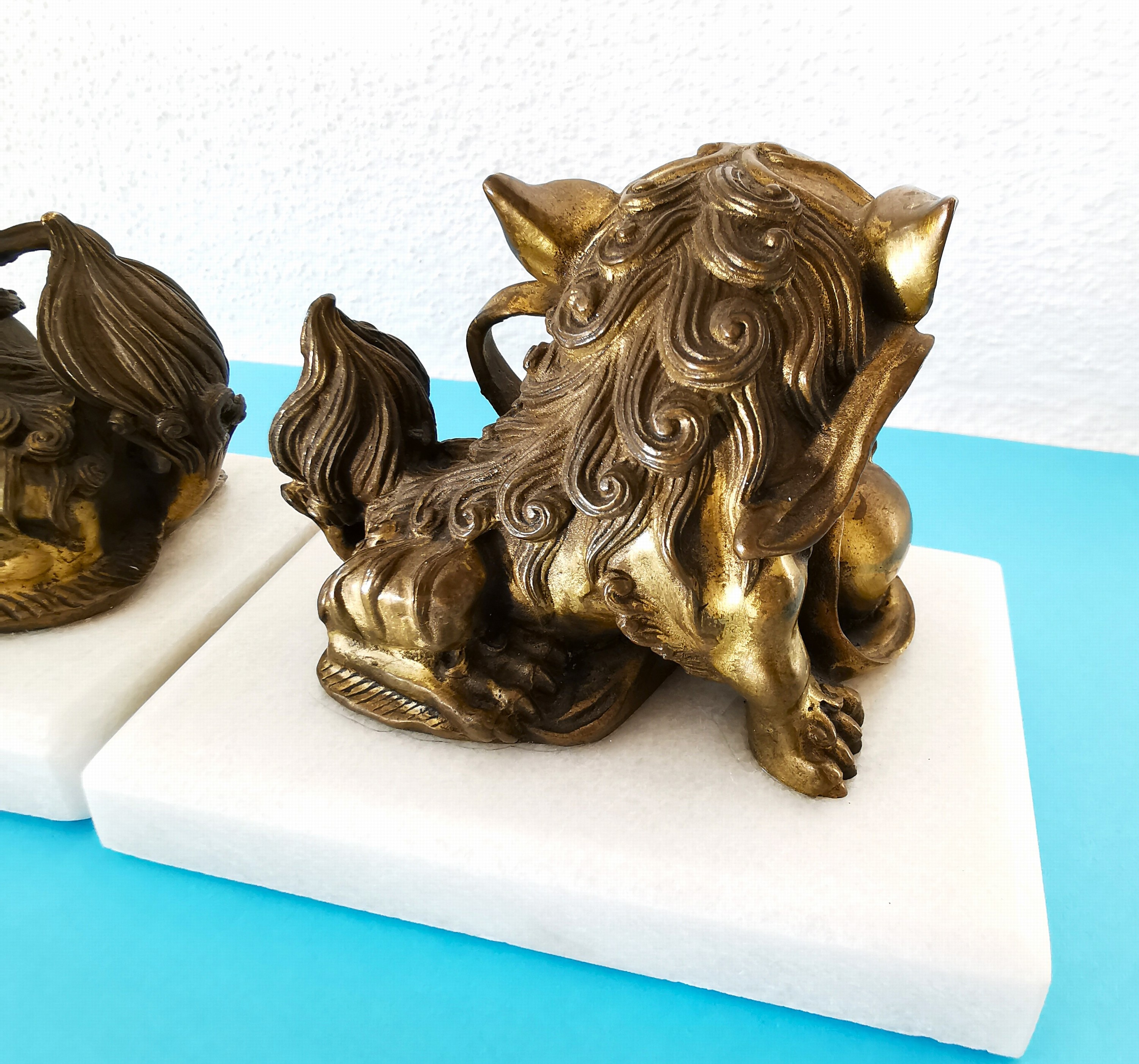 Detail c: Paar Foohunde bzw. Wächterlöwen, China, 20.Jh., Bronze, variierende Darstellungen, sekundär auf Alabasterplinthen montiert, 7 ,5x10x7 cm
