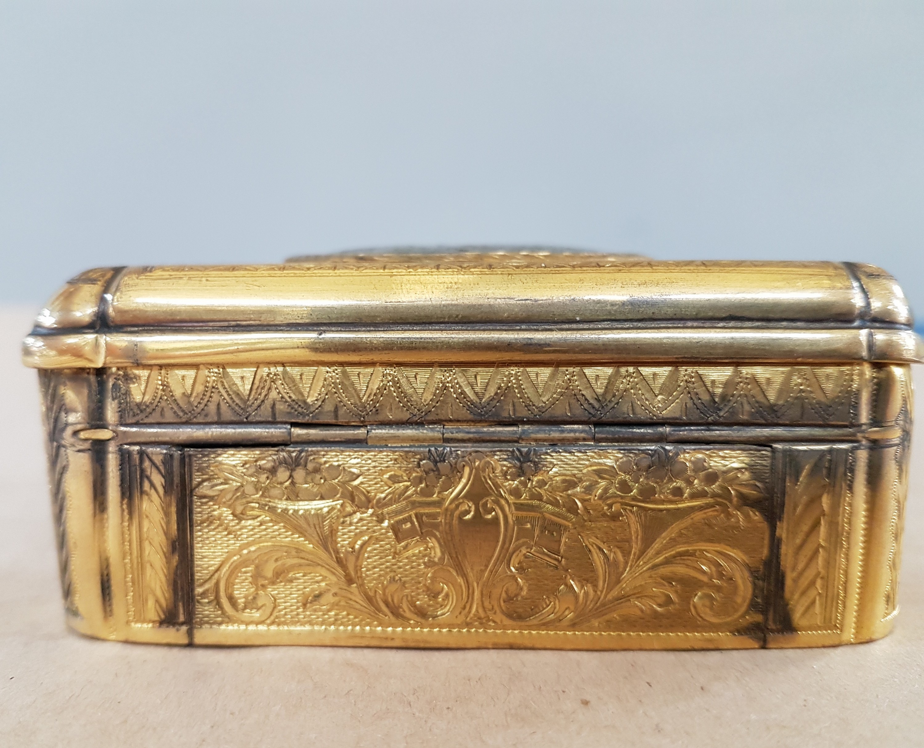 Detail d: Feine Singvogel-Spieldose, wohl Schweiz, um 1840, Metallgehäuse qualitätvoll vergoldet, graviert und guillochiert mit flächigem Dekor aus ...