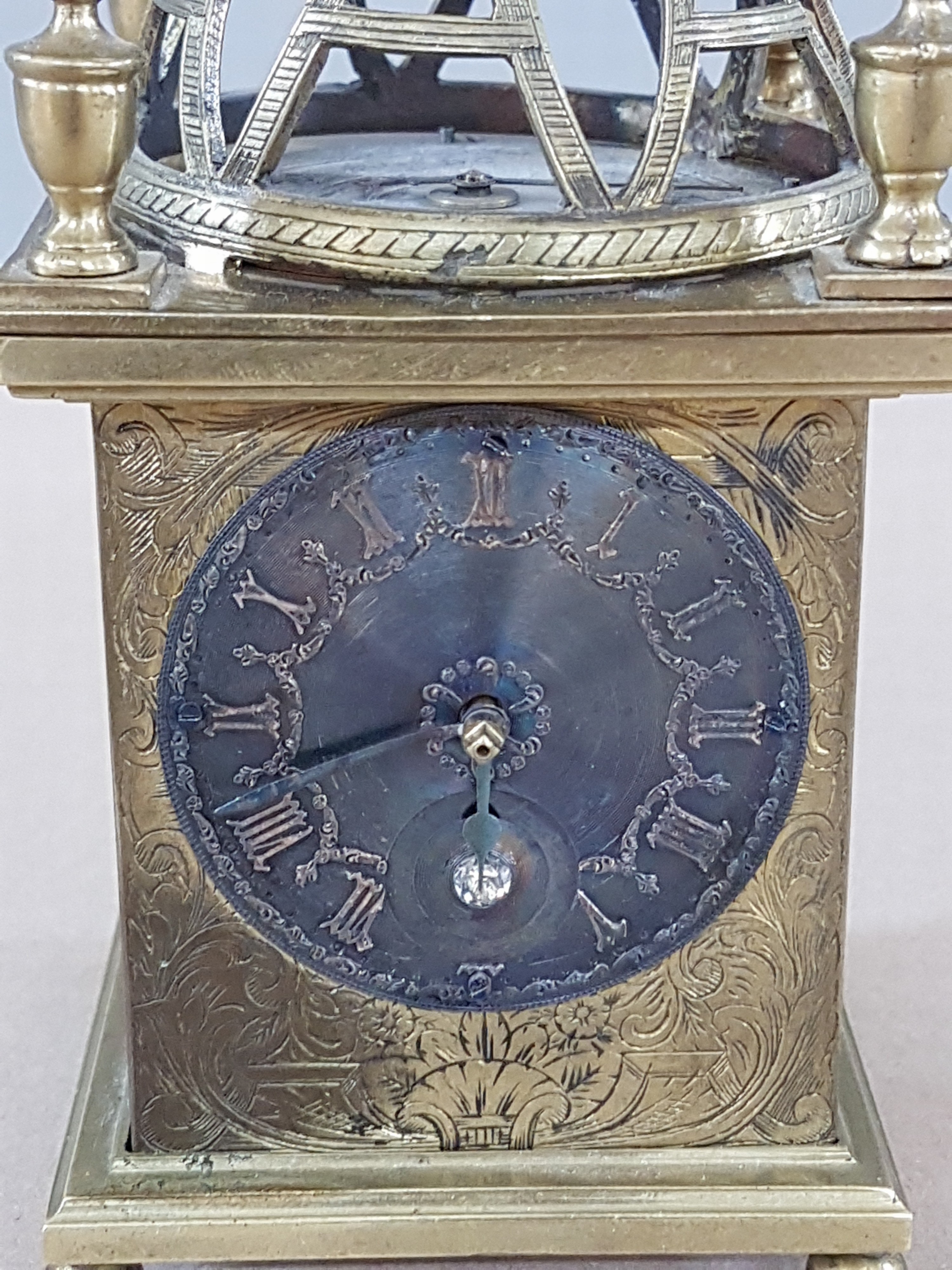 Detail b: Laternenuhr im Stil des 17.Jh., Ausführung wohl 20.Jh., Messinggehäuse, reich graviert, ornamental-floraler Dekor, rückseitiges Christusbild bzw. ...