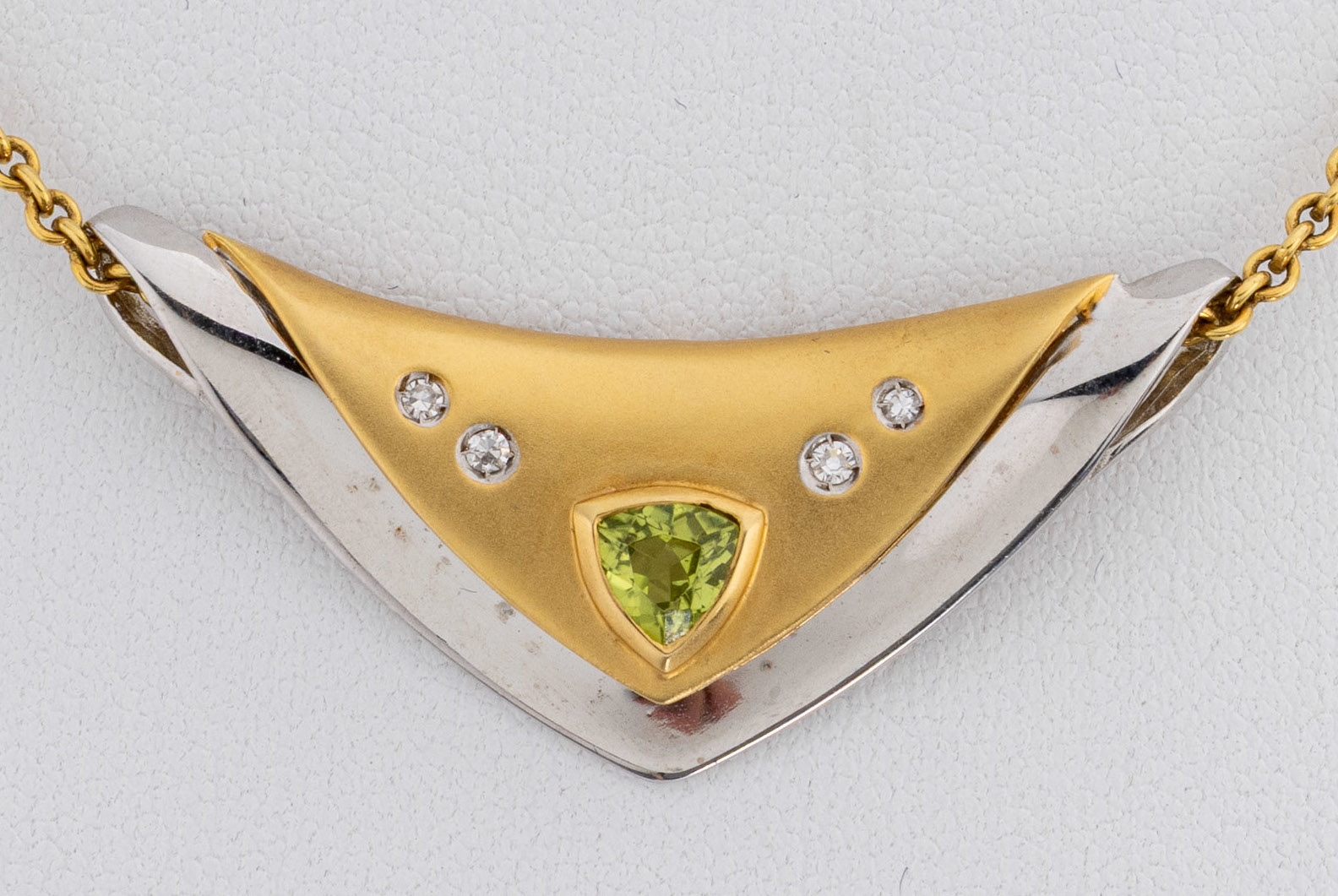 Detail a: 14 kt Gold Peridot-Diamant-Anhänger, GG/WG 585/000, z.T. poliert und satiniert, Peridot- Triangel ca. 0.50 ct, 4 8/8-Diamanten zus. ca.0.03 ct ...