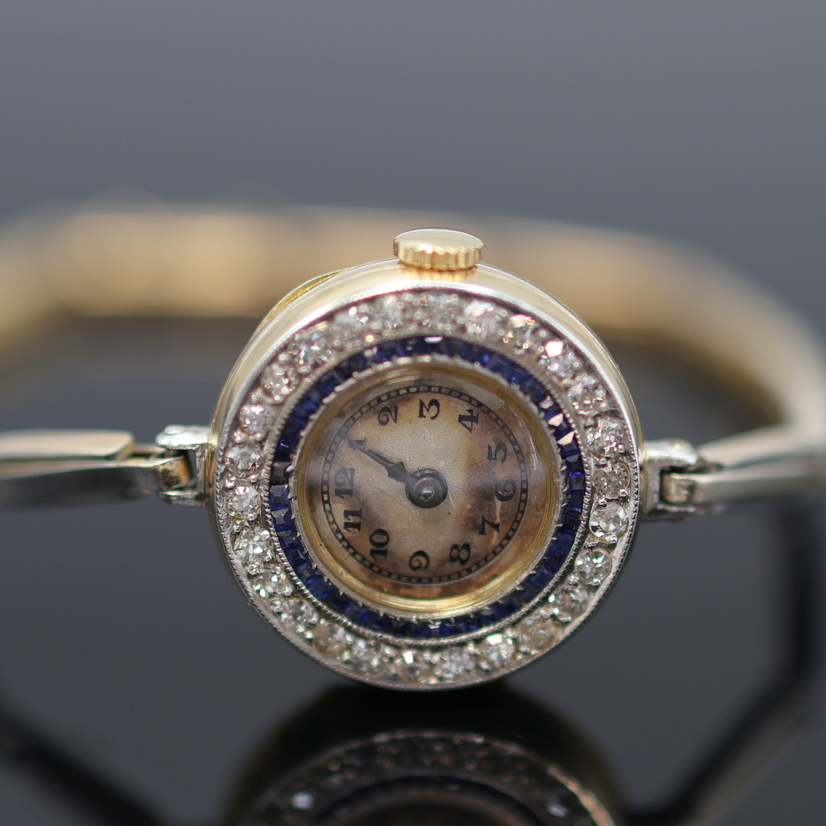 Detail a: Frühe mit Diamanten besetzte Armbanduhr in GG 750/000, Schweiz um 1920, Handaufzug, z. T. rhod. gefedertes Goldband, Scharnierboden, Lünette m. ...
