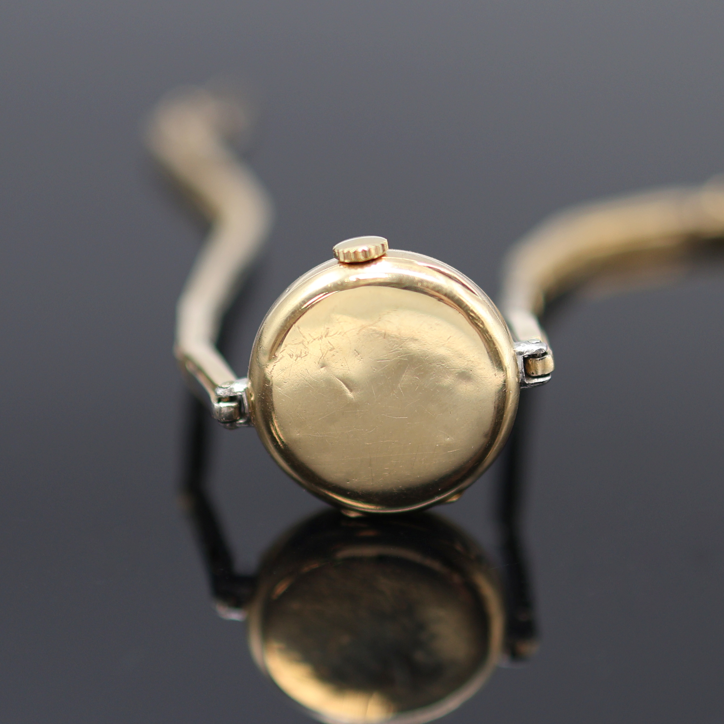Detail d: Frühe mit Diamanten besetzte Armbanduhr in GG 750/000, Schweiz um 1920, Handaufzug, z. T. rhod. gefedertes Goldband, Scharnierboden, Lünette m. ...