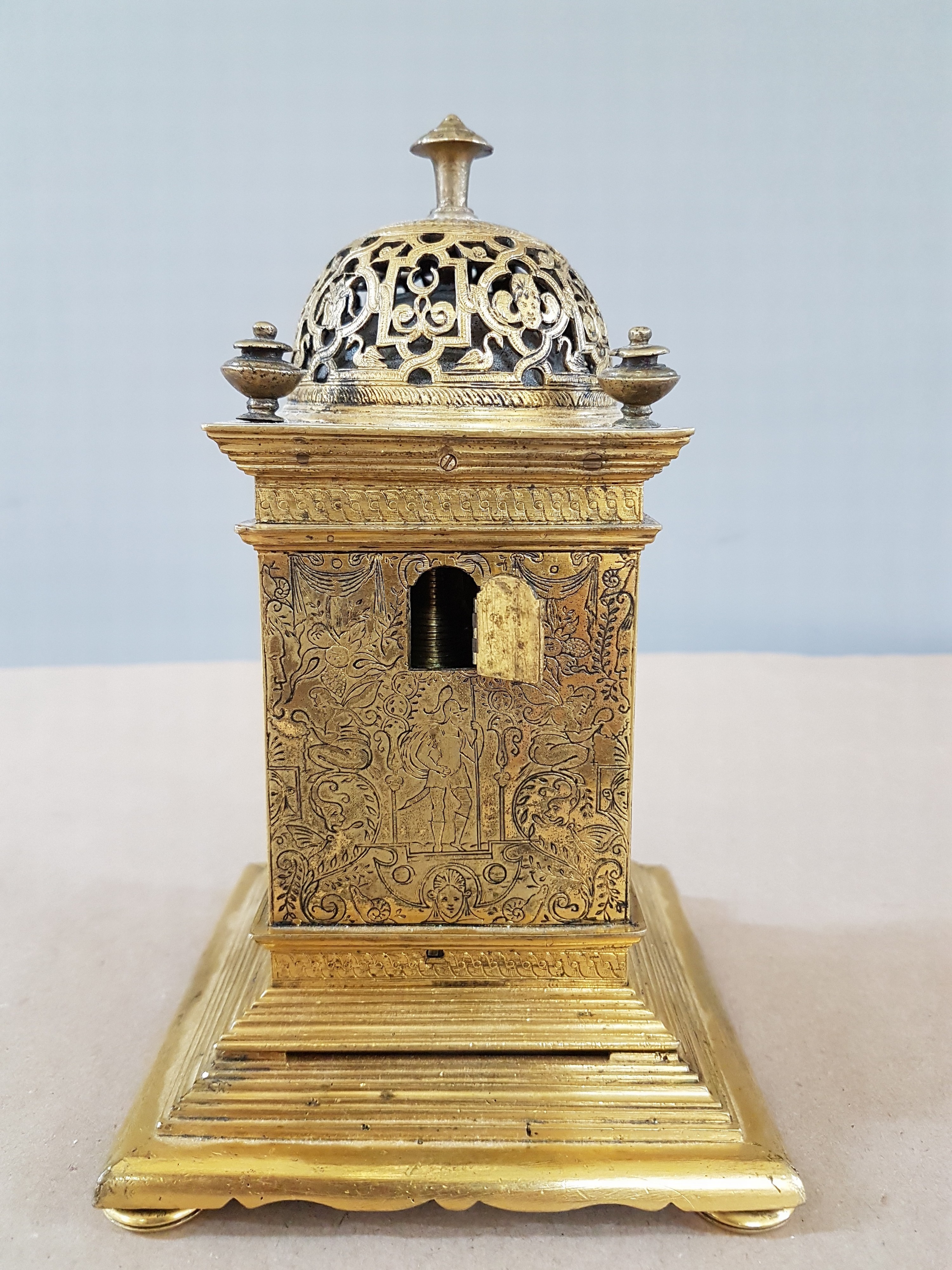 Detail i: Kleine Türmchenuhr, Spätrenaissance, Anfang 17. Jh., das vierseitig vergoldete Messinggehäuse steht auf einem getreppten Sockel, allseitig sehr ...