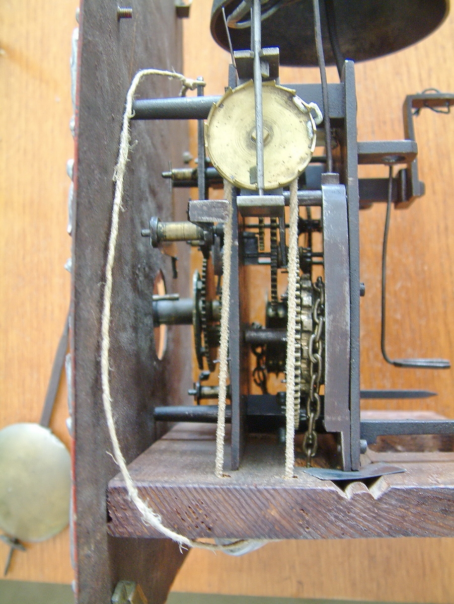 Detail d: Werk einer Wanduhr/Standuhr, Franz Jacob Braun Eberbach am Neckar, im 1780, Bogenzifferblatt, Eisen rot gefaßt, Eckverzierungen, im Arkus ...