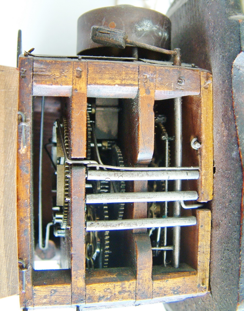 Detail b: Jockele-Uhr, Schwarzwald um 1850/60, Porzellanschild in sog. Tropfenform, mit Flußlandschaft bemalt, Goldbemalung berieben, Holz unterfüttert, ...