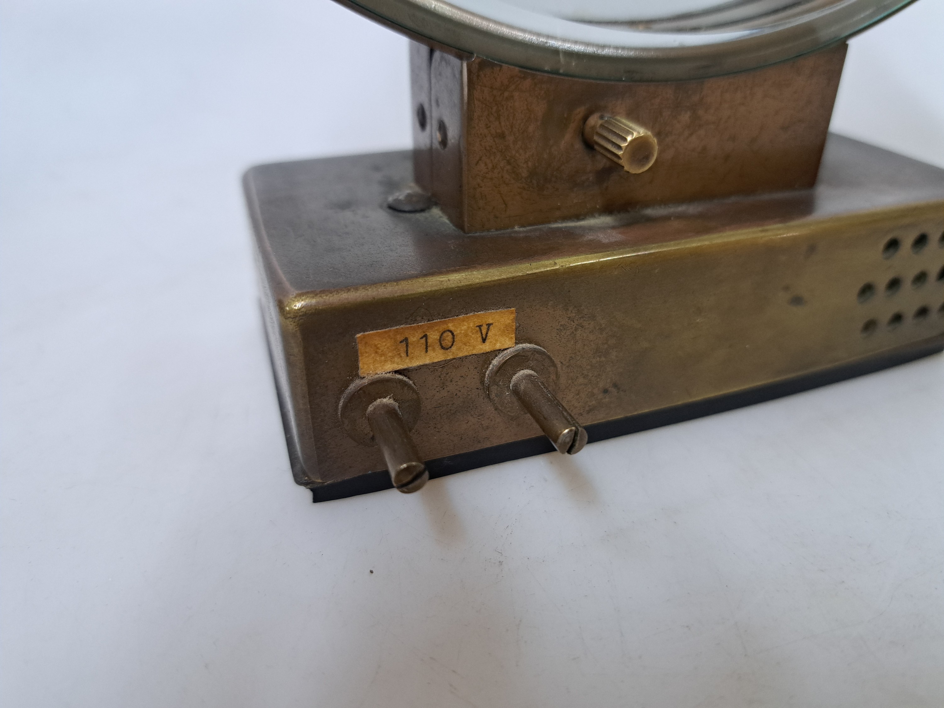 Detail g: Elektr. Tischuhr Jaeger LeCoultre Comet, um 1920, Messinggehäuse, im Boden und seitlich mit Lüftungsöffnungen, externe Zeitverstellung sowie ...