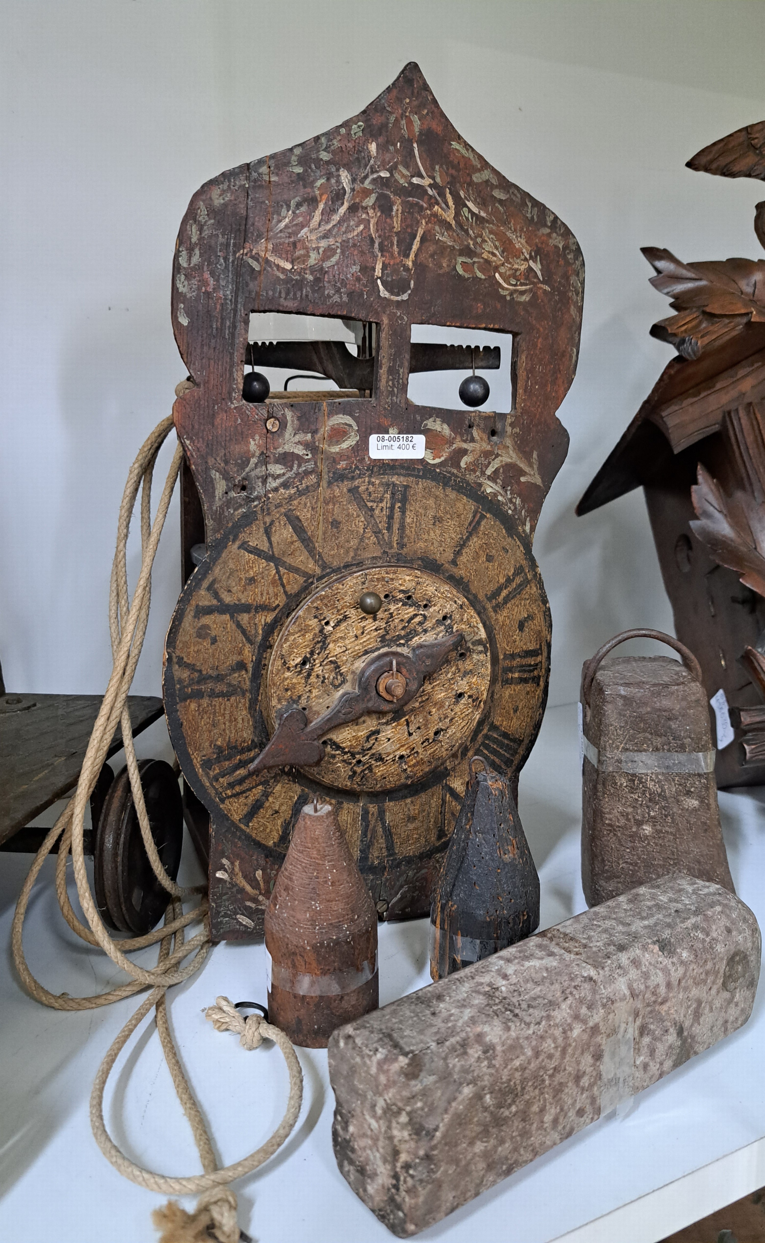 Detail a: Frühe Holzräderuhr, Schwarzwald um 1750, bemaltes Schild (altersbedingt erhalten), mit sichtbarem Waagbalken mit Ausgleichsgewicht, Holzräder und ...