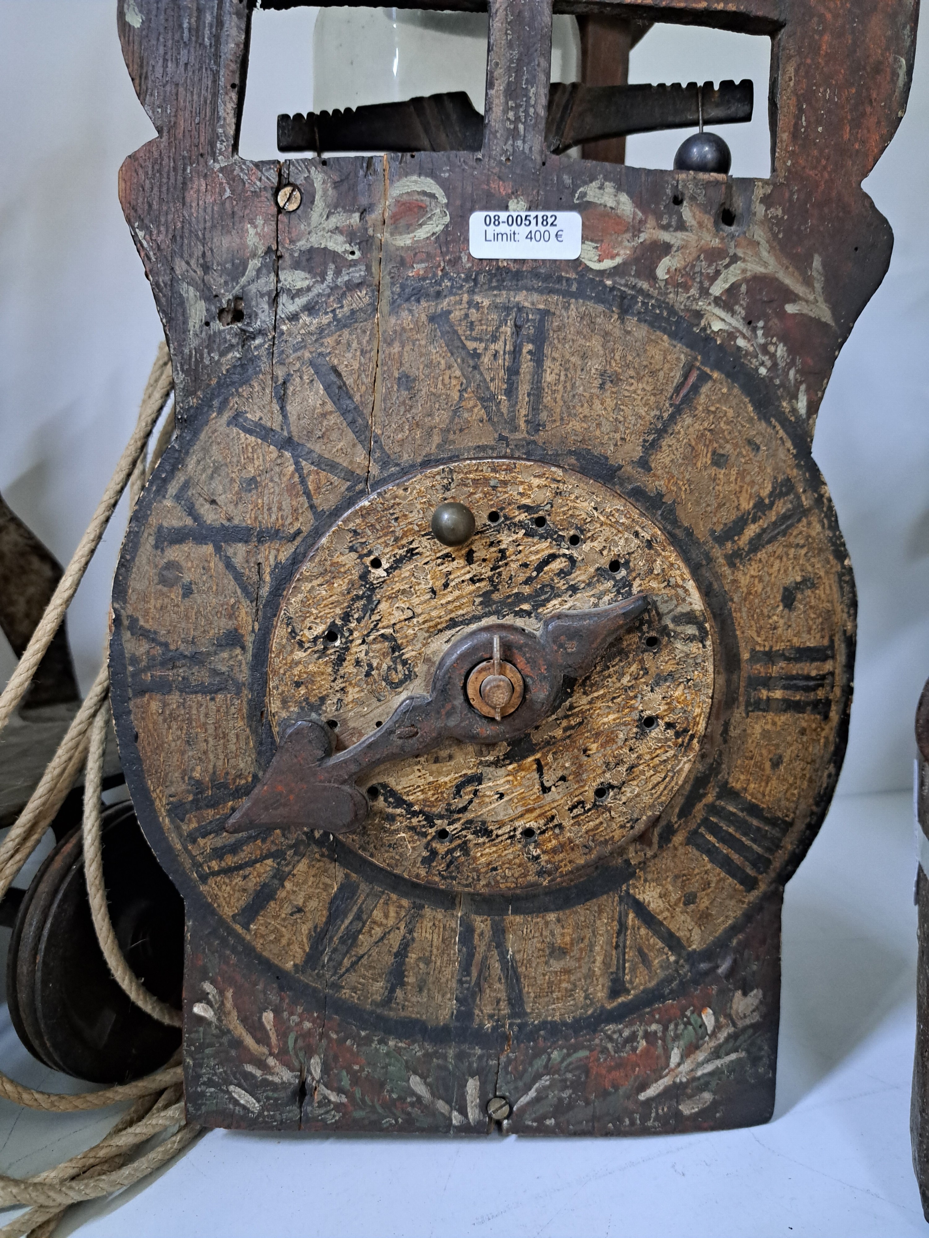 Detail e: Frühe Holzräderuhr, Schwarzwald um 1750, bemaltes Schild (altersbedingt erhalten), mit sichtbarem Waagbalken mit Ausgleichsgewicht, Holzräder und ...