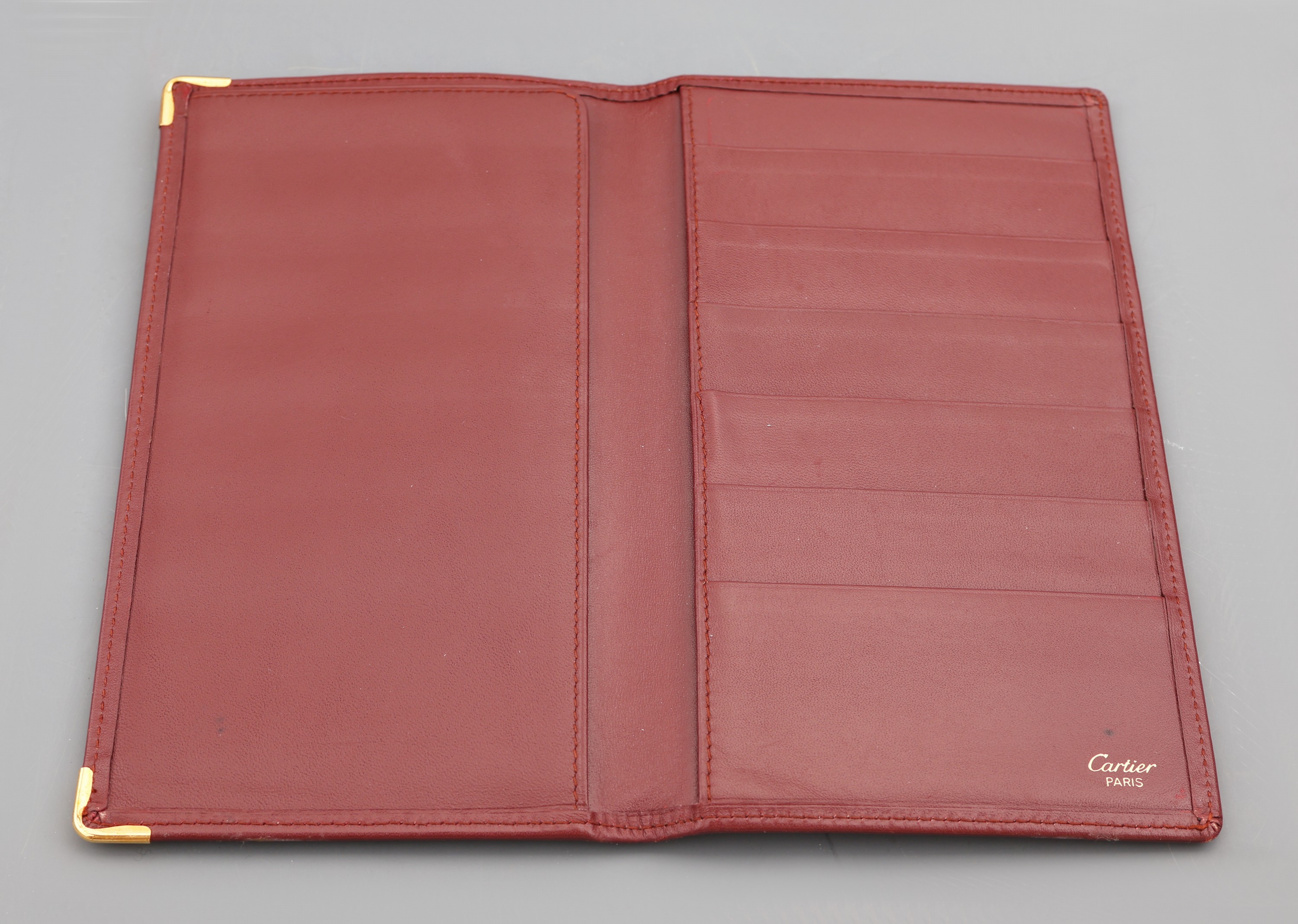 Detail a: CARTIER Konvolut 2 Leder Accessoires, bordeauxrotes Leder, 1 x Agendamappe mit Trageriemen, Innenfächer, ca. 22 x 17 cm und Brieftasche für ...