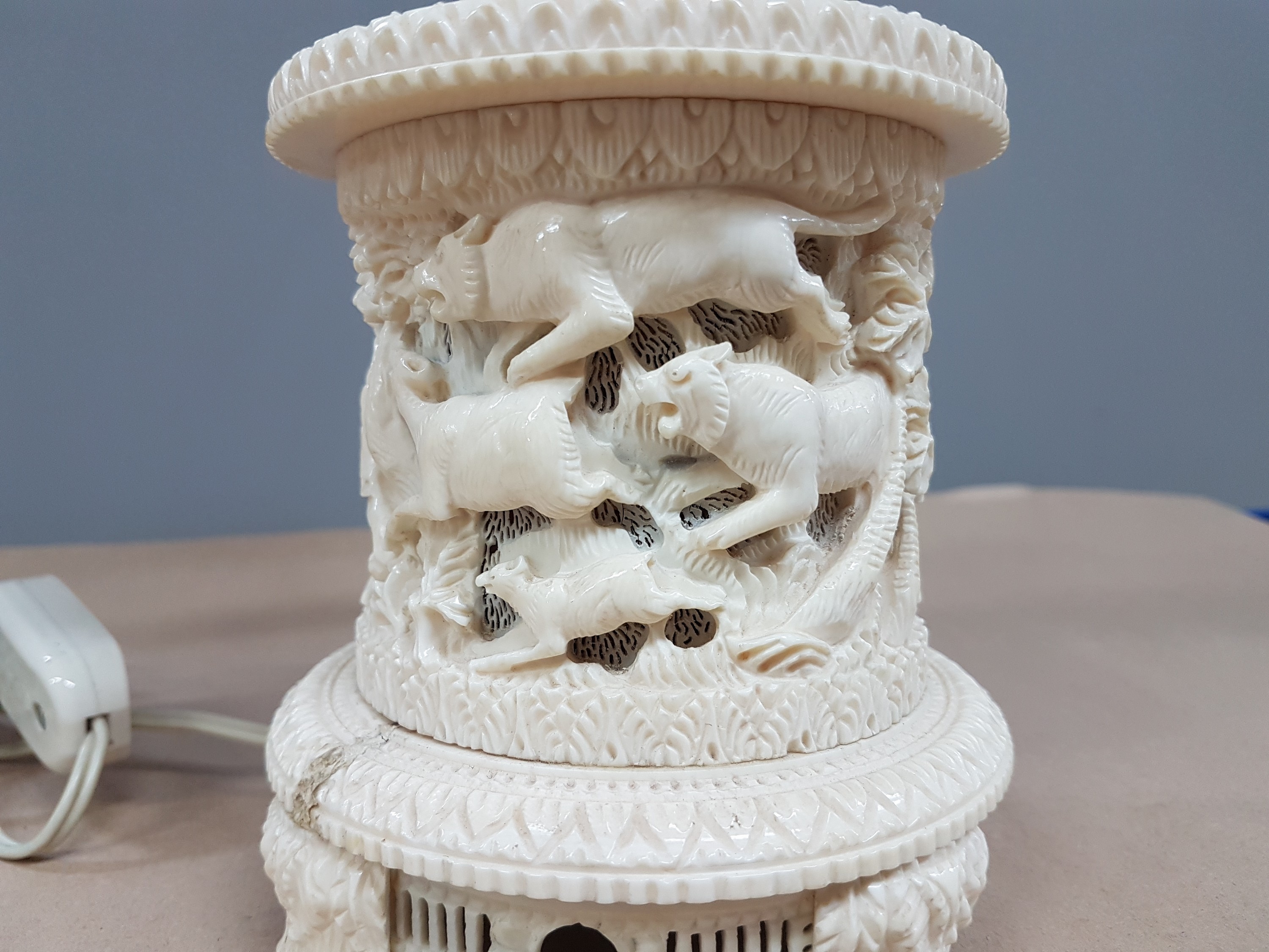 Detail e: Fünfarmige Elfenbeinleuchte, Indien, um 1930, Sockel aus einem Hohlstück eines Stoßzahnes, reich geschnitzt, mit exotischen Wildtieren, u.a. ...