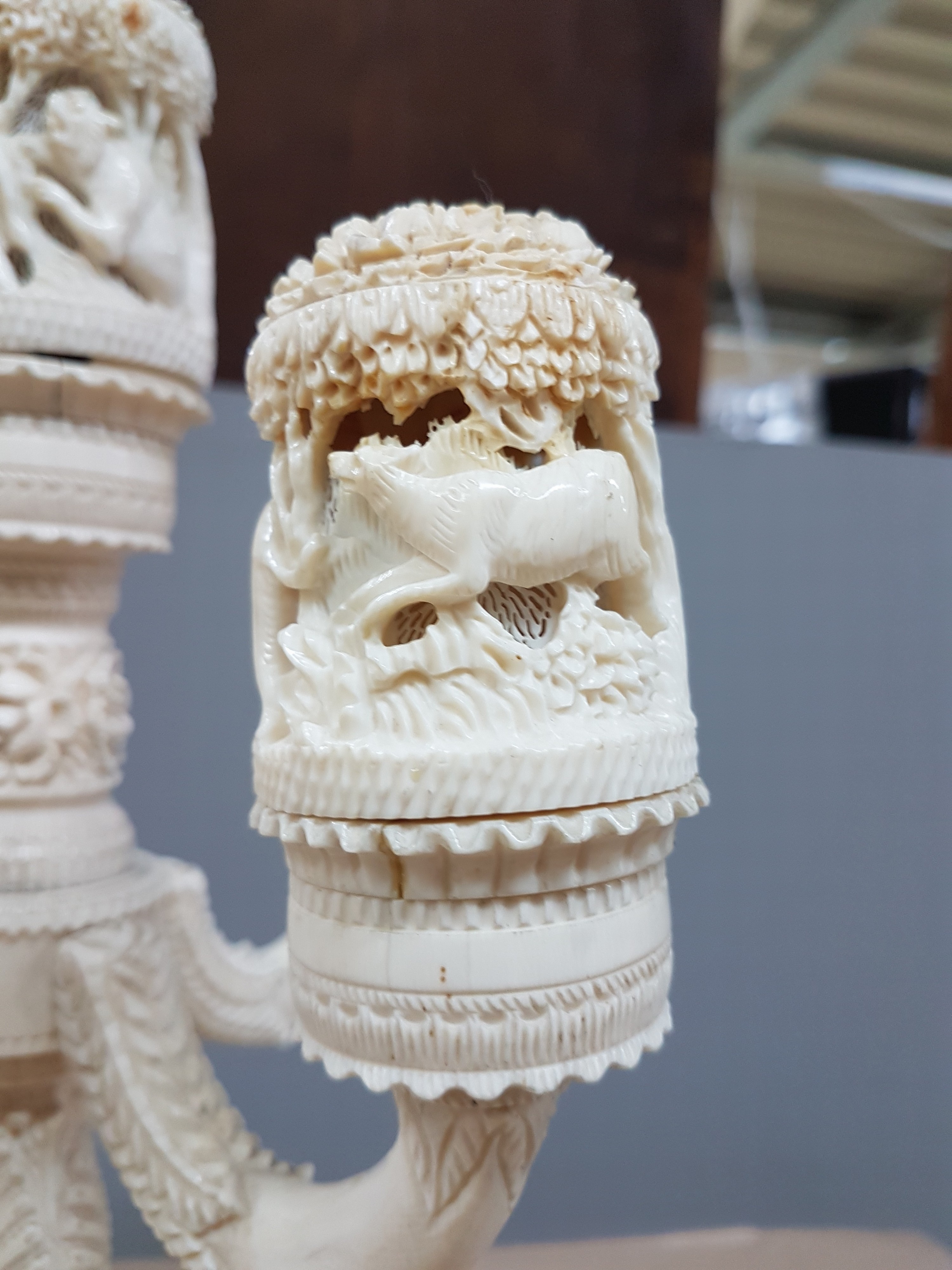 Detail g: Fünfarmige Elfenbeinleuchte, Indien, um 1930, Sockel aus einem Hohlstück eines Stoßzahnes, reich geschnitzt, mit exotischen Wildtieren, u.a. ...