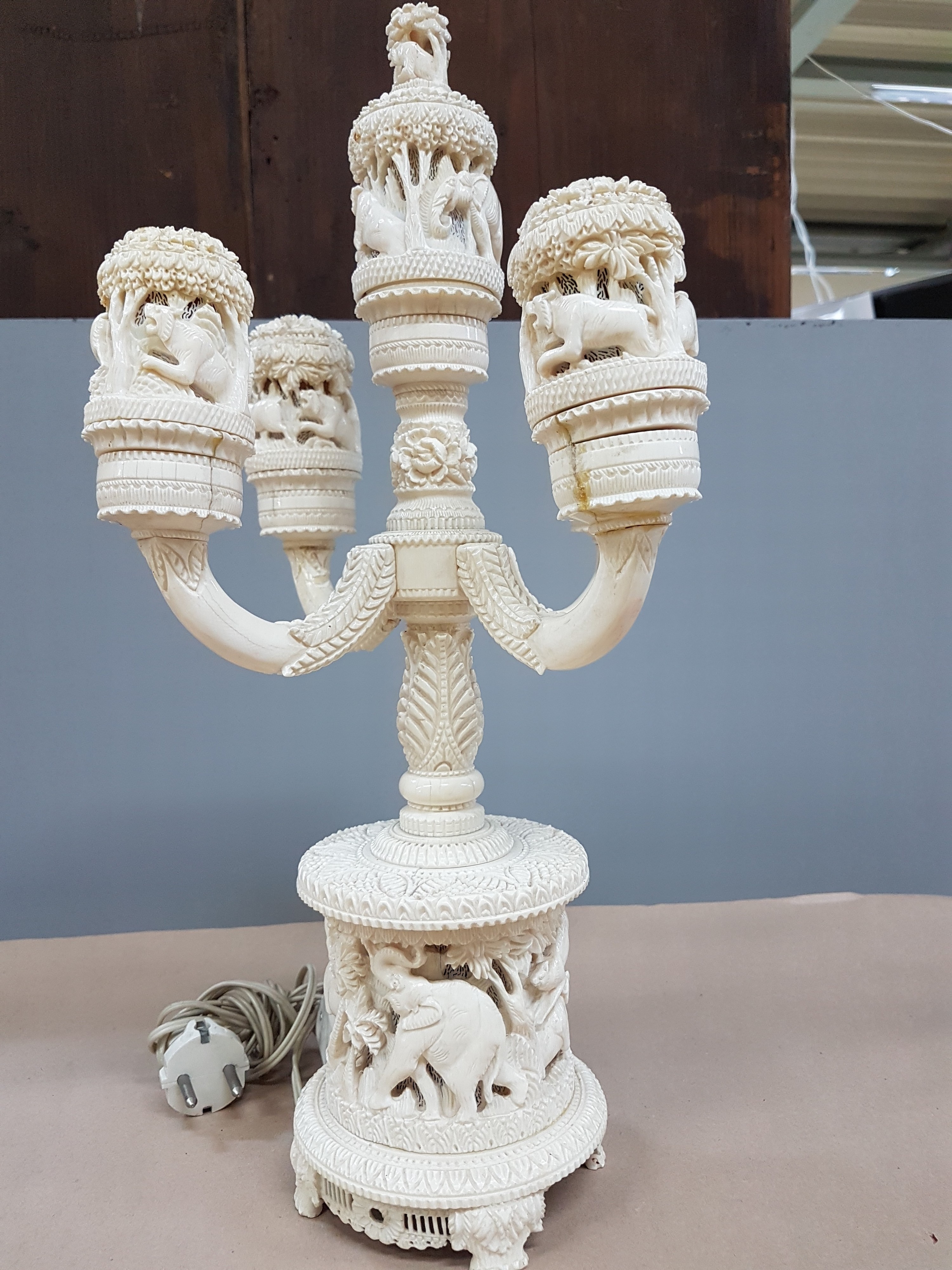 Detail i: Fünfarmige Elfenbeinleuchte, Indien, um 1930, Sockel aus einem Hohlstück eines Stoßzahnes, reich geschnitzt, mit exotischen Wildtieren, u.a. ...