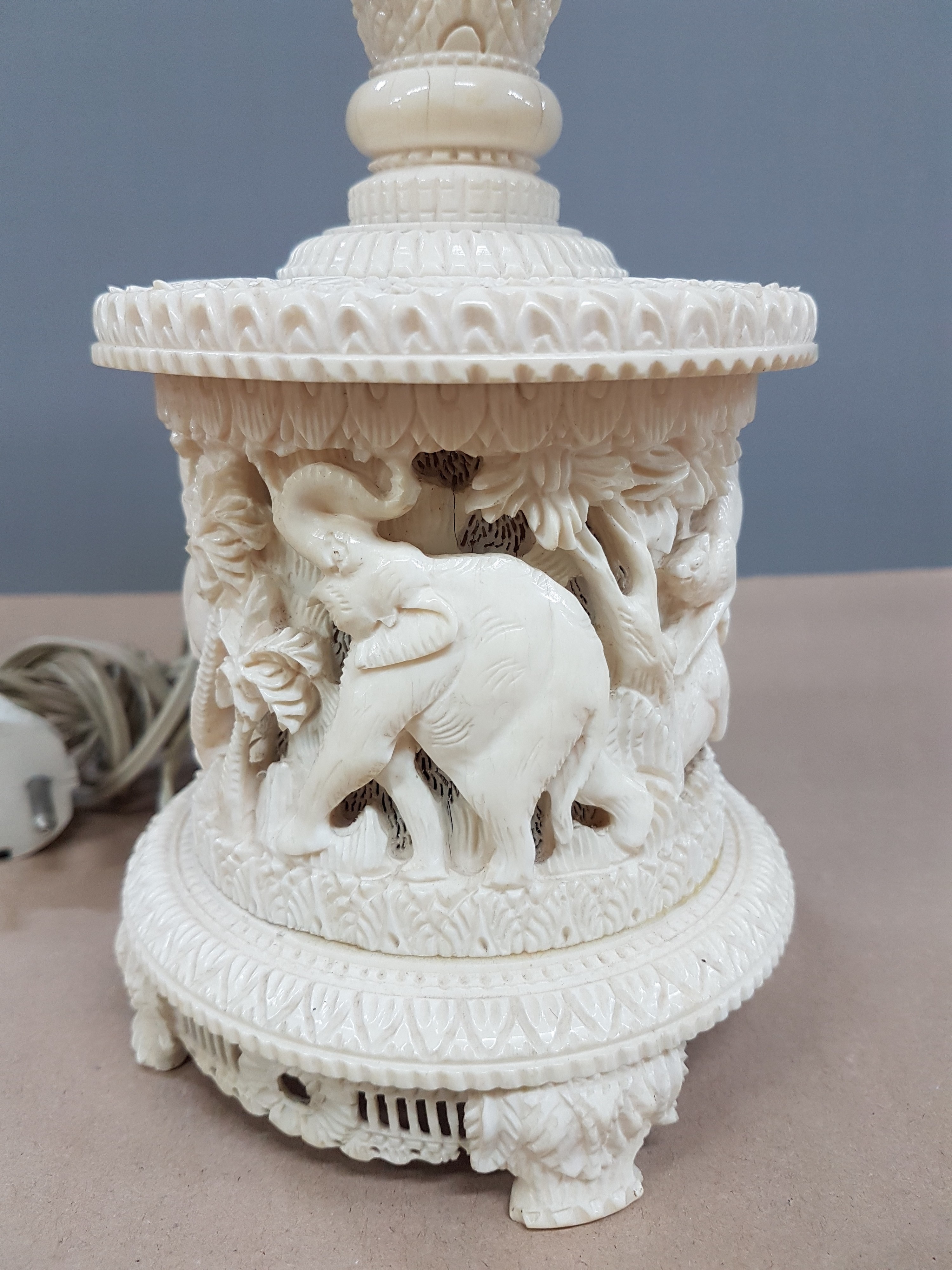 Detail j: Fünfarmige Elfenbeinleuchte, Indien, um 1930, Sockel aus einem Hohlstück eines Stoßzahnes, reich geschnitzt, mit exotischen Wildtieren, u.a. ...