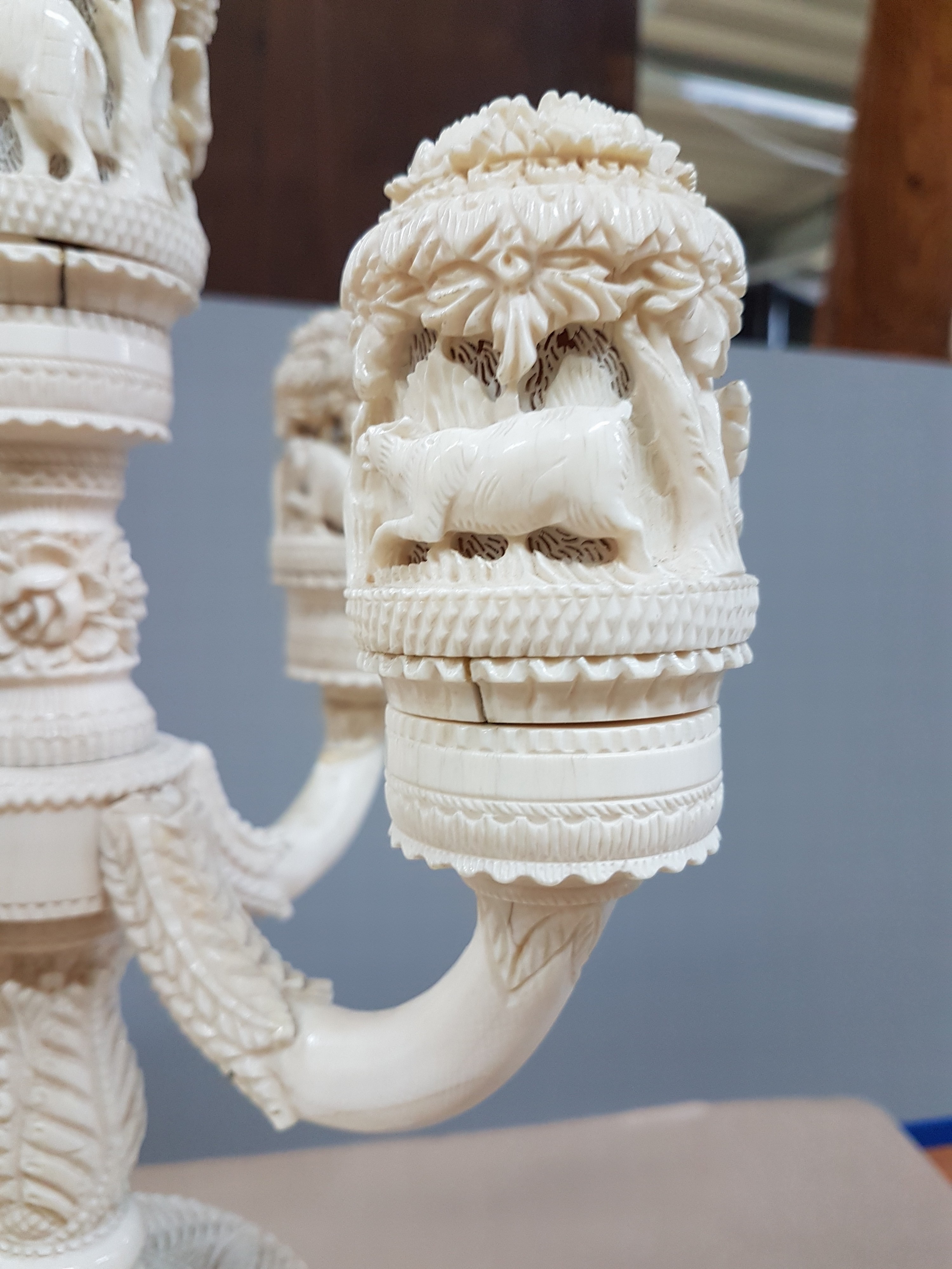 Detail q: Fünfarmige Elfenbeinleuchte, Indien, um 1930, Sockel aus einem Hohlstück eines Stoßzahnes, reich geschnitzt, mit exotischen Wildtieren, u.a. ...