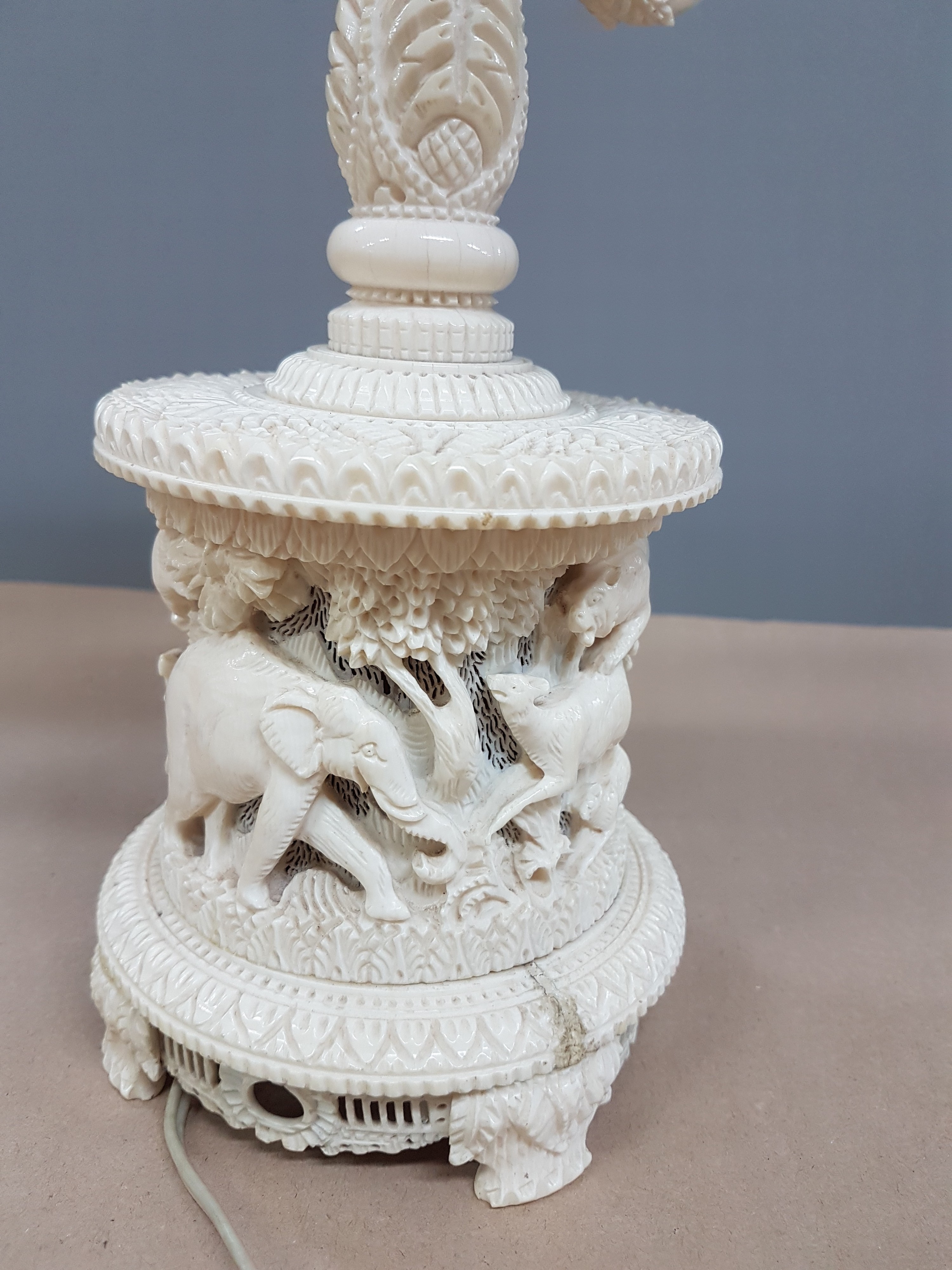 Detail t: Fünfarmige Elfenbeinleuchte, Indien, um 1930, Sockel aus einem Hohlstück eines Stoßzahnes, reich geschnitzt, mit exotischen Wildtieren, u.a. ...