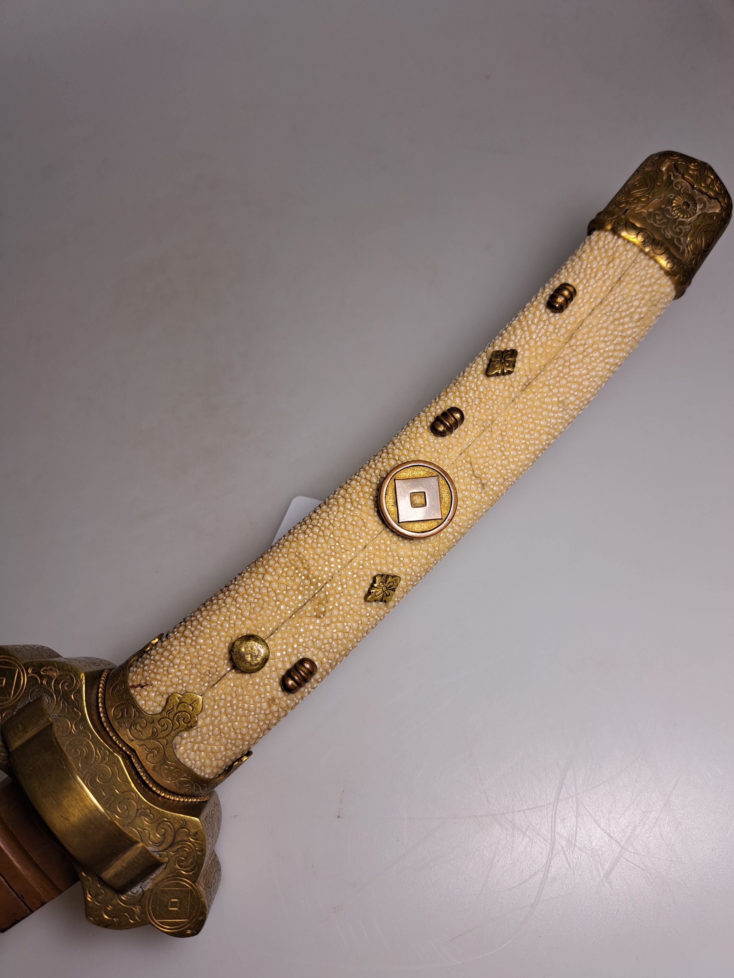 Detail a: Katana, Japan, 1. Hälfte 20. Jh., Griff mit Rochenhaut und 12 kleinen Menukis, Messingmontierung fein graviert, Scheide jaspisfarben mit Sterndekor, ...