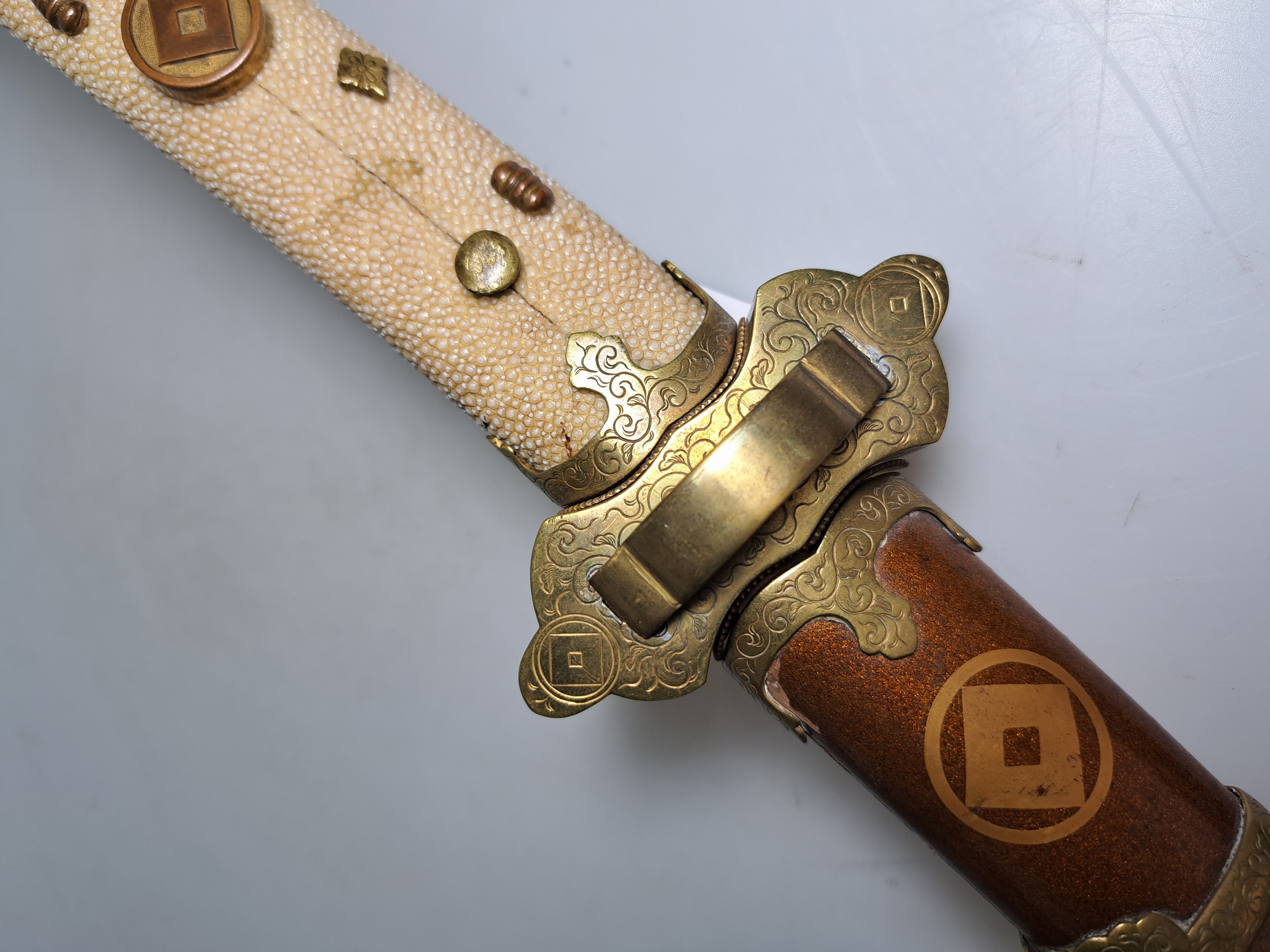 Detail c: Katana, Japan, 1. Hälfte 20. Jh., Griff mit Rochenhaut und 12 kleinen Menukis, Messingmontierung fein graviert, Scheide jaspisfarben mit Sterndekor, ...