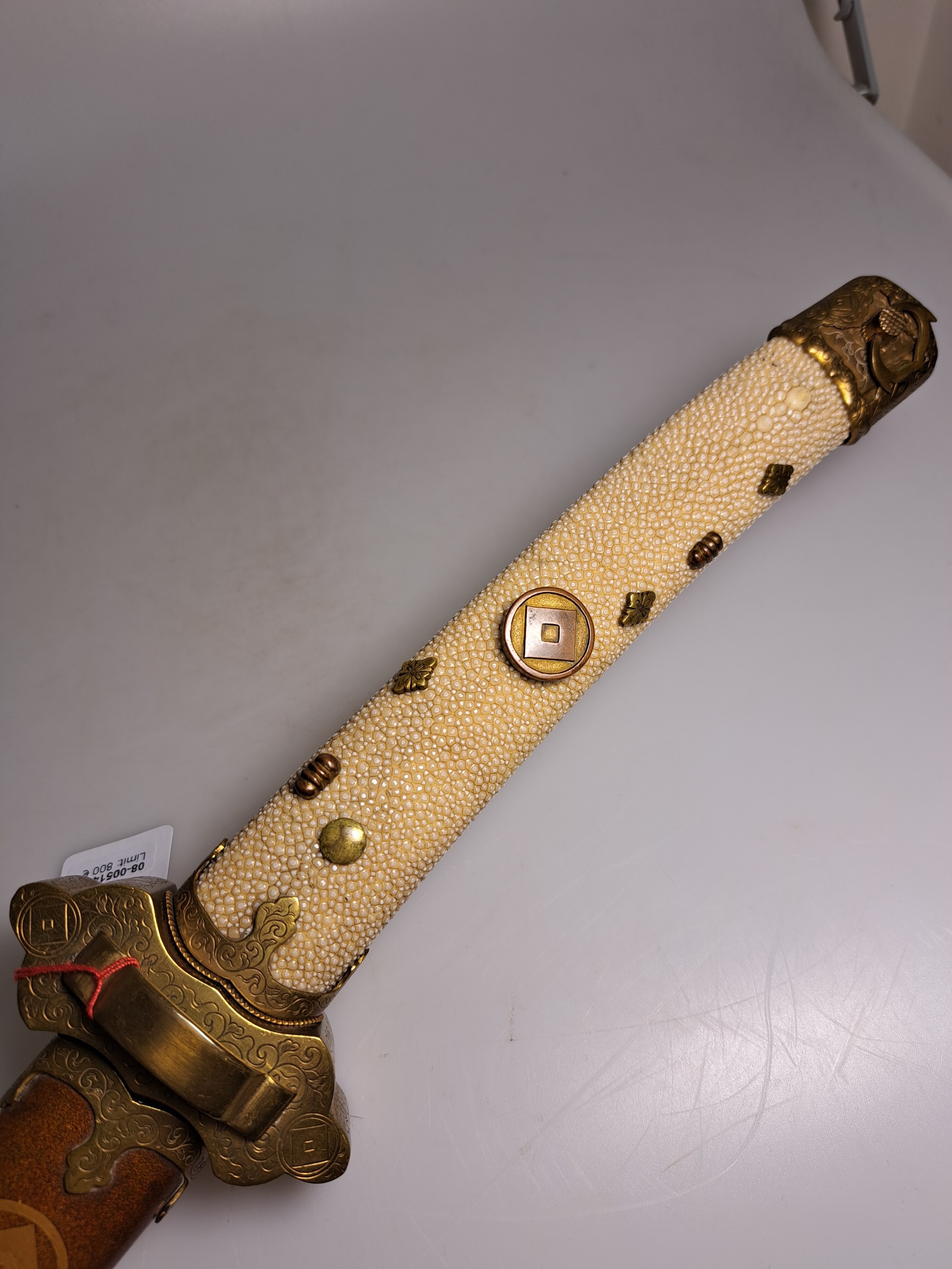 Detail d: Katana, Japan, 1. Hälfte 20. Jh., Griff mit Rochenhaut und 12 kleinen Menukis, Messingmontierung fein graviert, Scheide jaspisfarben mit Sterndekor, ...