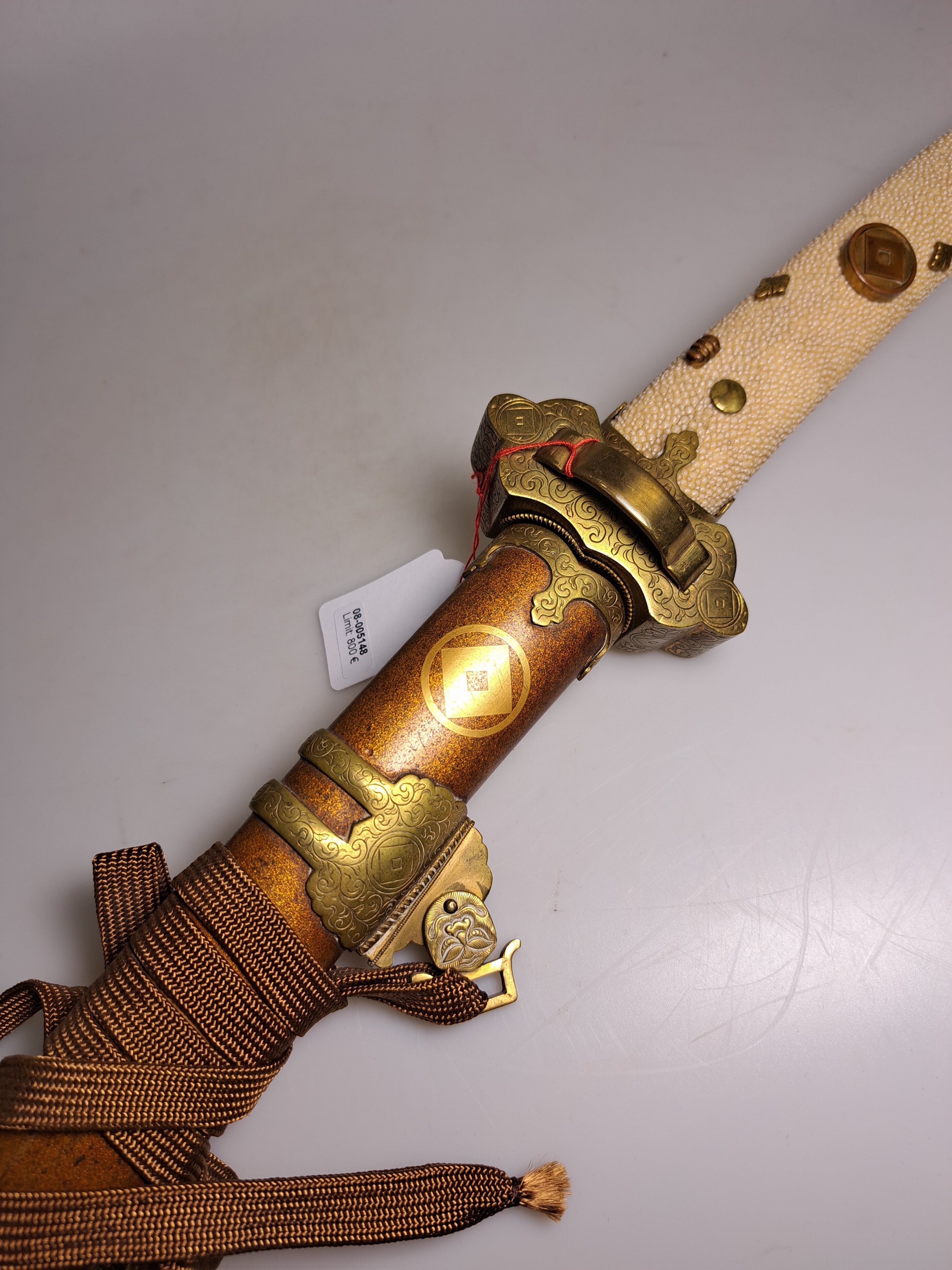 Detail e: Katana, Japan, 1. Hälfte 20. Jh., Griff mit Rochenhaut und 12 kleinen Menukis, Messingmontierung fein graviert, Scheide jaspisfarben mit Sterndekor, ...