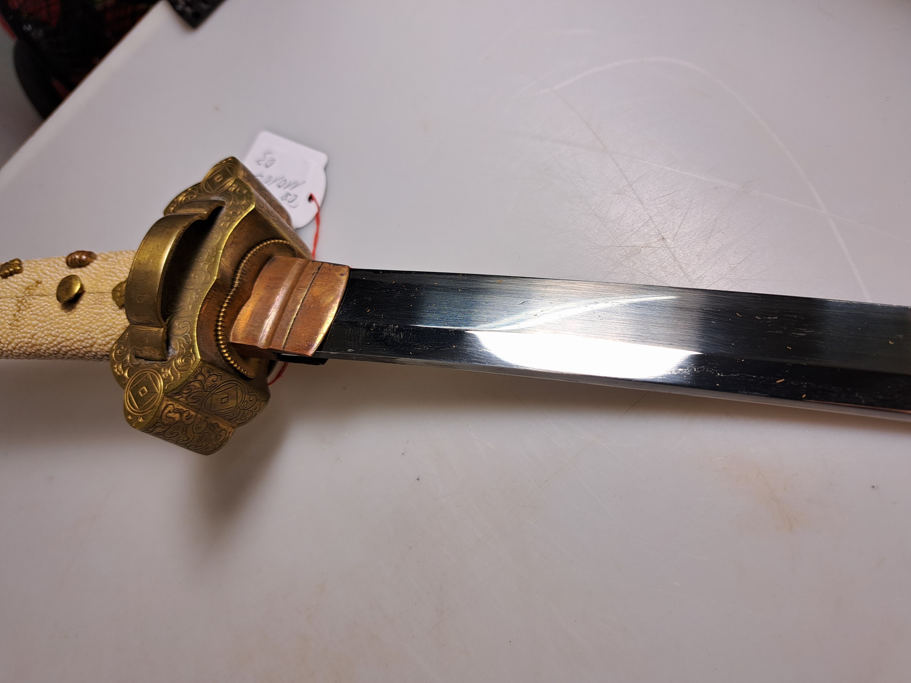 Detail i: Katana, Japan, 1. Hälfte 20. Jh., Griff mit Rochenhaut und 12 kleinen Menukis, Messingmontierung fein graviert, Scheide jaspisfarben mit Sterndekor, ...