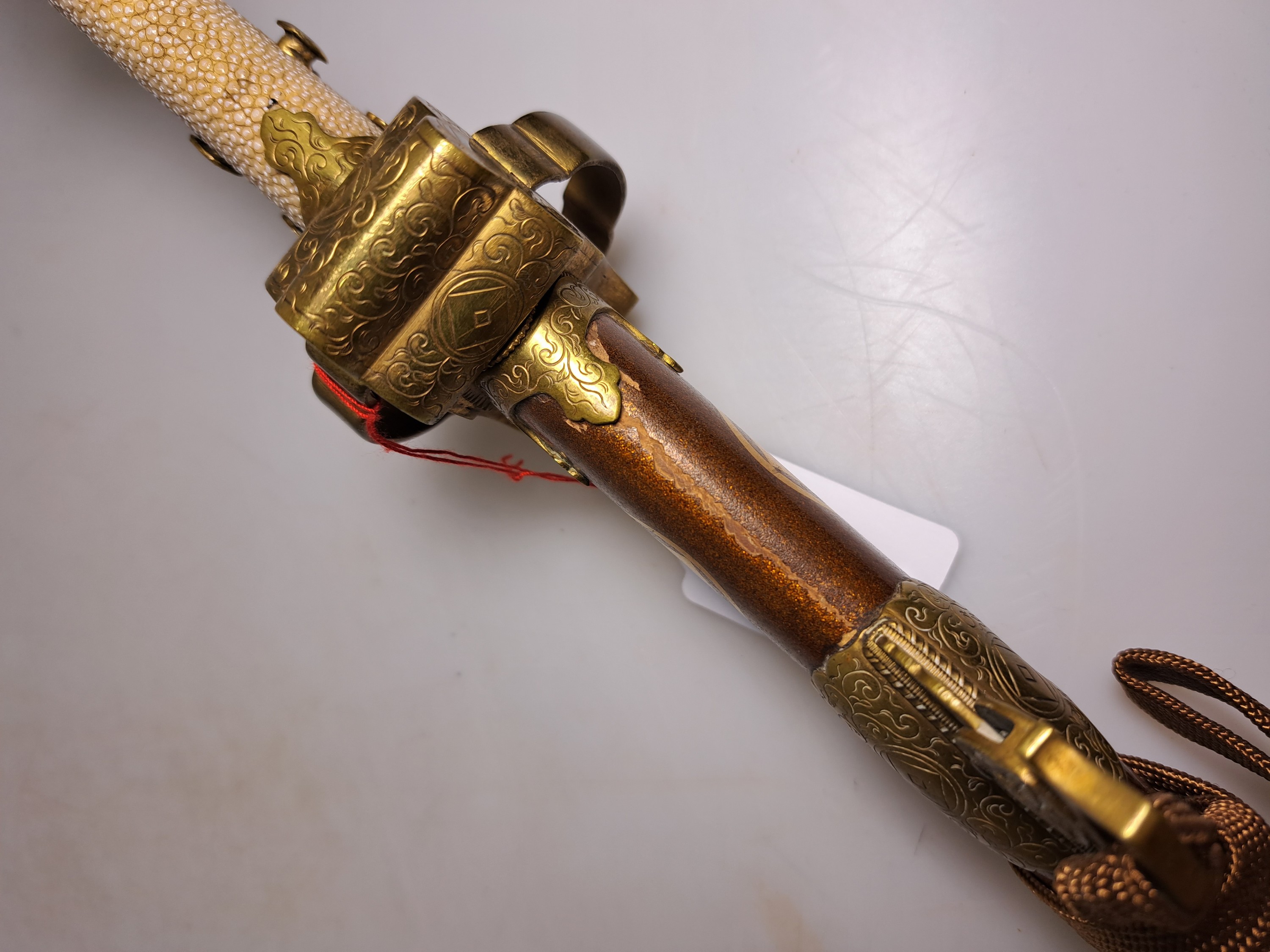 Detail m: Katana, Japan, 1. Hälfte 20. Jh., Griff mit Rochenhaut und 12 kleinen Menukis, Messingmontierung fein graviert, Scheide jaspisfarben mit Sterndekor, ...
