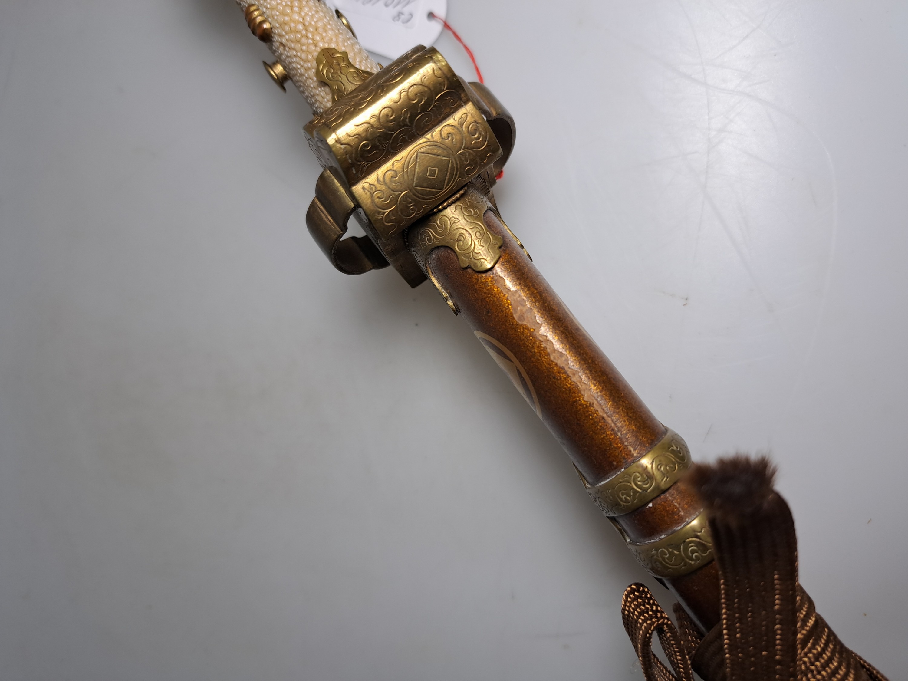 Detail n: Katana, Japan, 1. Hälfte 20. Jh., Griff mit Rochenhaut und 12 kleinen Menukis, Messingmontierung fein graviert, Scheide jaspisfarben mit Sterndekor, ...