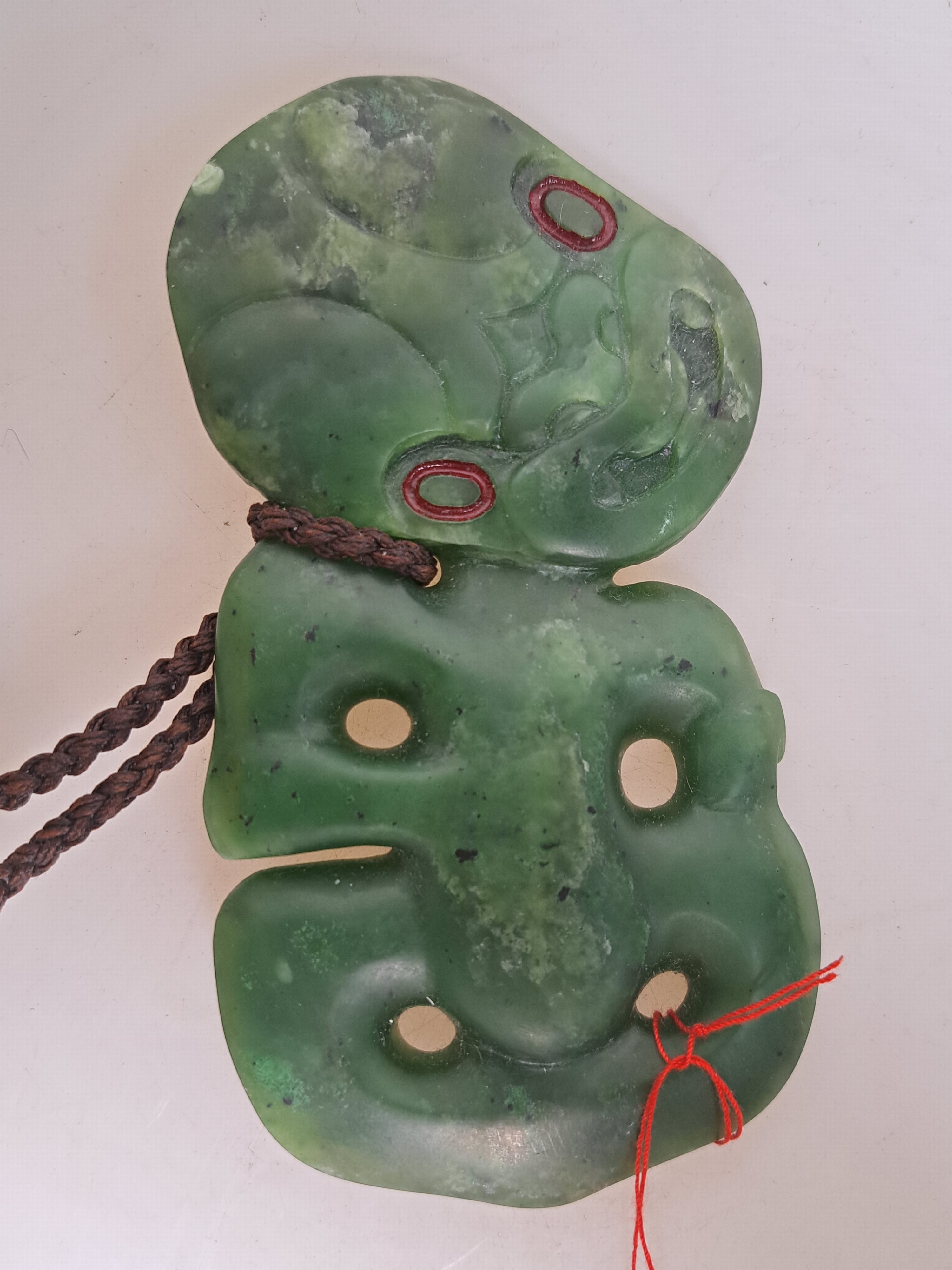 Detail a: Hei Tiki, Amulett der Maori, Neuseeland, Nephrit, sog. Greenstone, geschnitzt und geritzt, Augen mit Siegelwachs, H. ca. 14cm