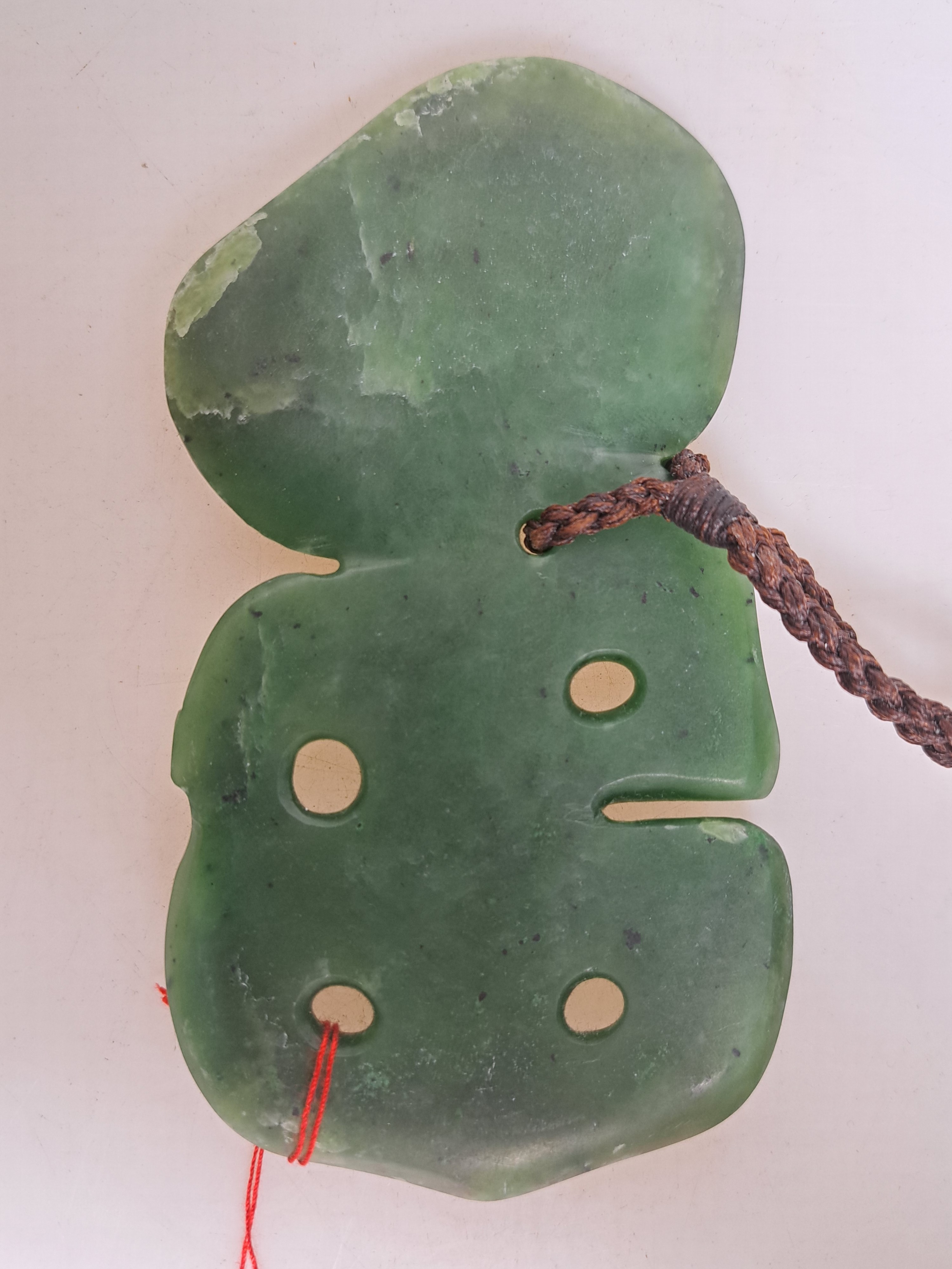 Detail b: Hei Tiki, Amulett der Maori, Neuseeland, Nephrit, sog. Greenstone, geschnitzt und geritzt, Augen mit Siegelwachs, H. ca. 14cm