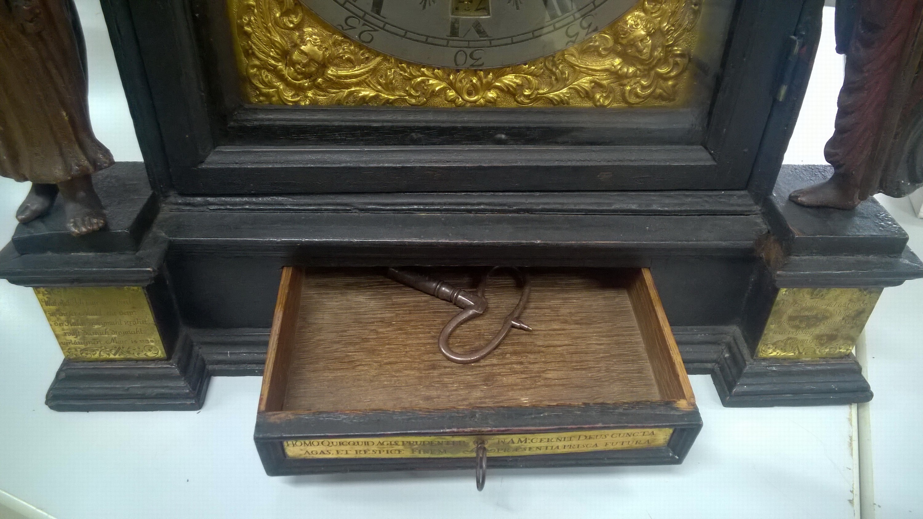Detail f: Stockuhr, Süddeutschland, 18. Jh. schwarz gefasstes Holzgehäuse, profiliert, (ehemals mit Füßen), Glastüre vo. und hi., Sprenggiebel, Uhr ...