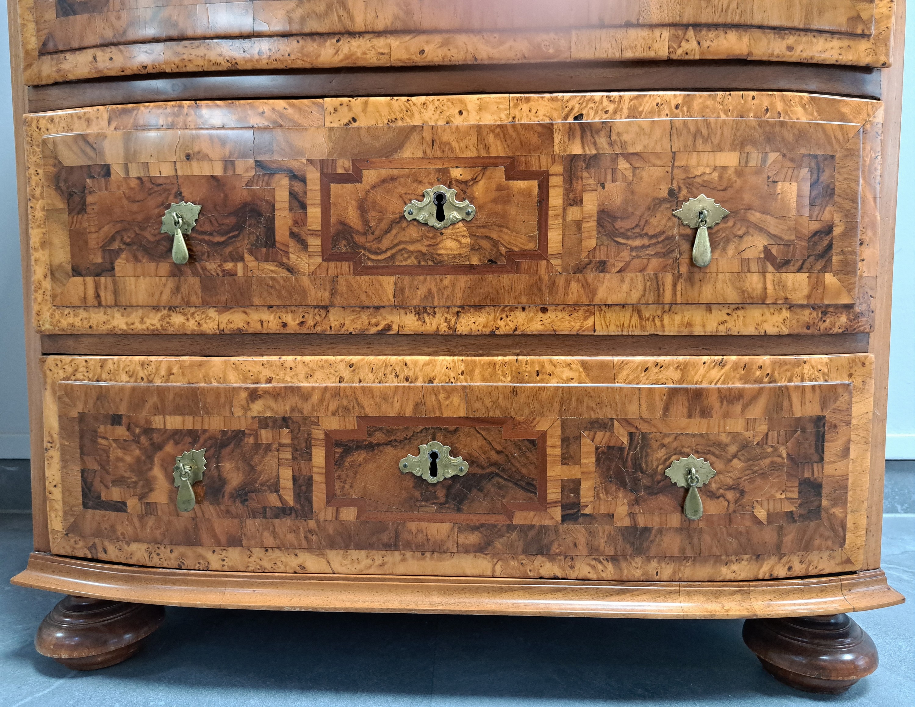Detail c: Herrenkommode, Barock, 18.Jh., Nußbaumfurnier, Deckplatte und Seiten mit aufwendigem Wurzelnussfurnier, Bandintarsien, geschwungene Front, ...