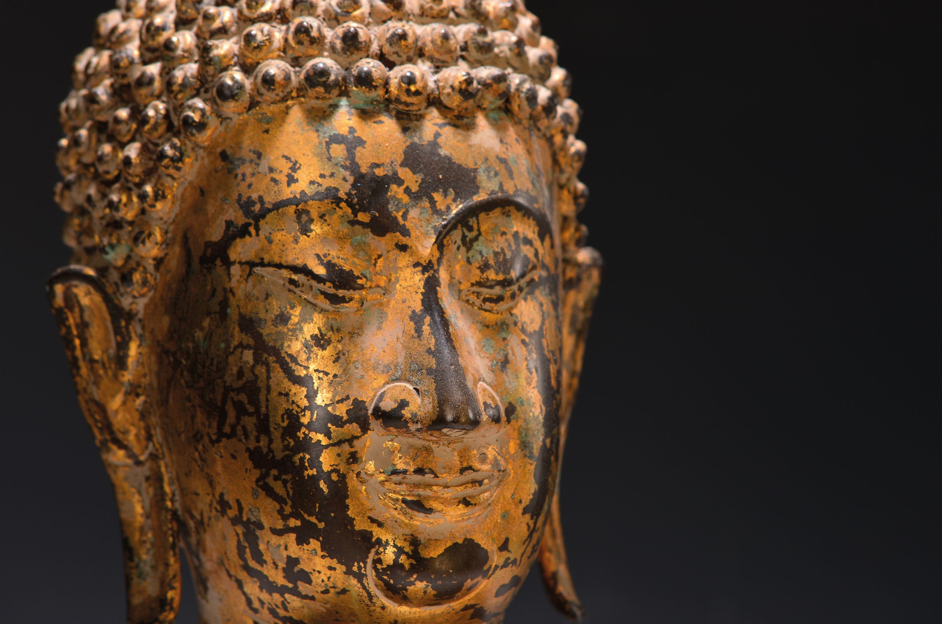 Detail a: Buddhakopf, thailändisch, 20.Jh., Metall, blattvergoldet, auf Holzsockel, H. 44 cm