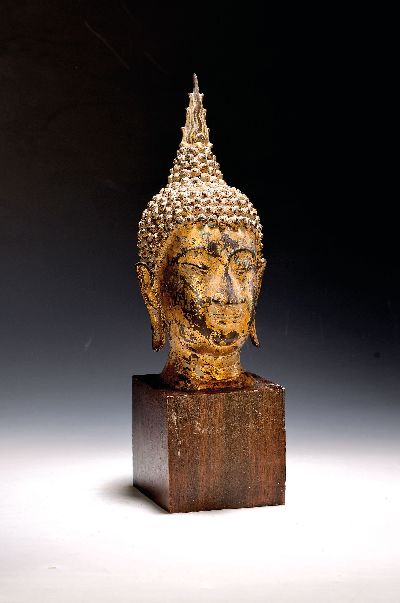 Image Buddha head, Thai, 20th century, metal, gold leaf, on a wooden base, h. 44 cm