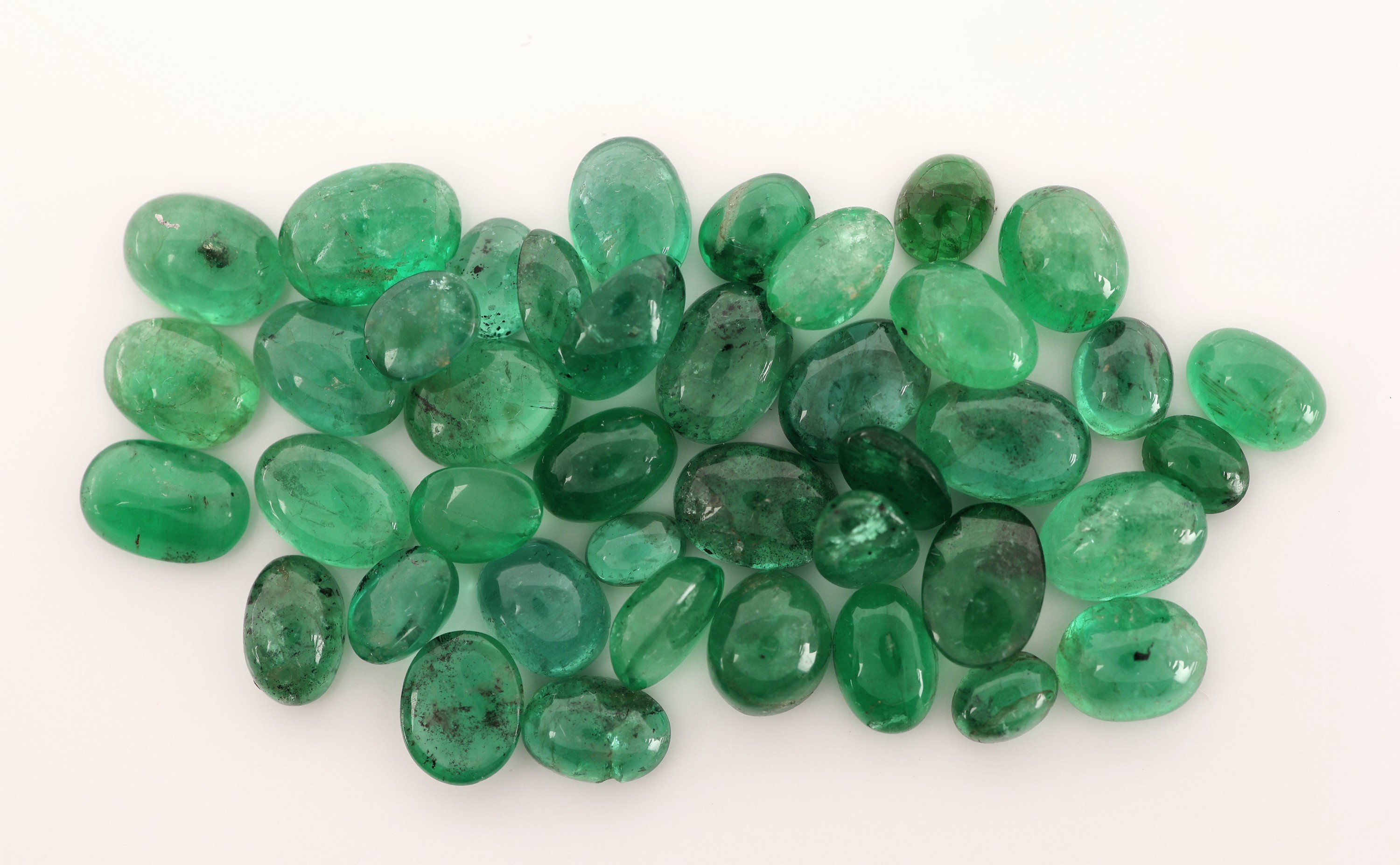 Detail c: Lot lose Smaragd-Cabochons zus. ca. 24.59 ct, versch. Größen und Formen
