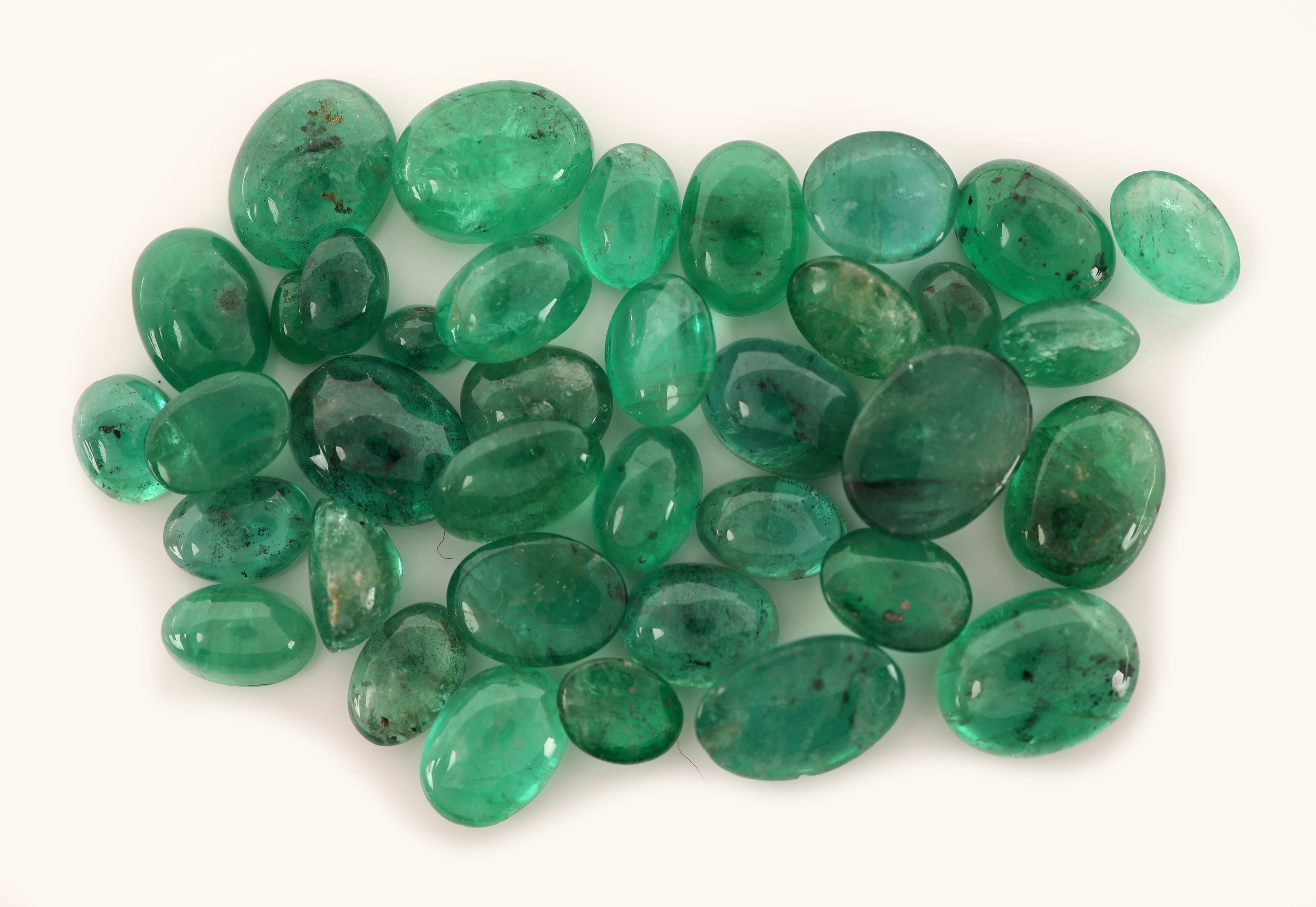 Detail c: Lot lose Smaragd-Cabochons zus. ca. 25.15 ct, versch. Größen und Formen